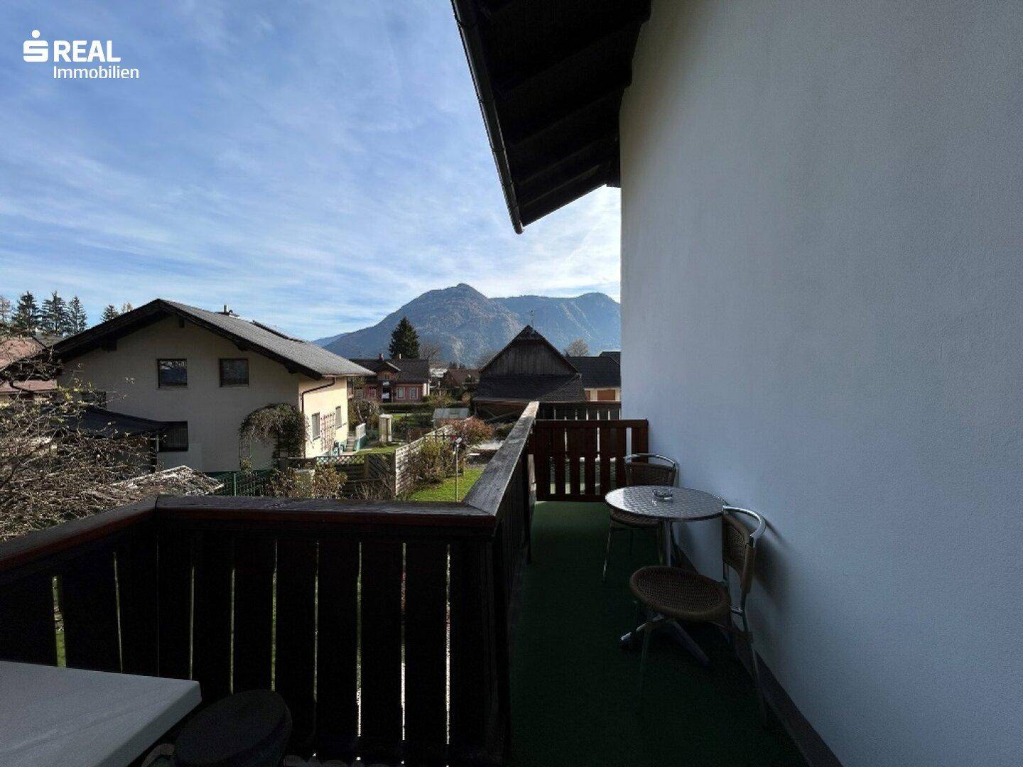 Gemütlicher Balkon mit Sitzgelegenheit und weitem Blick auf die umliegende Berglandschaft.