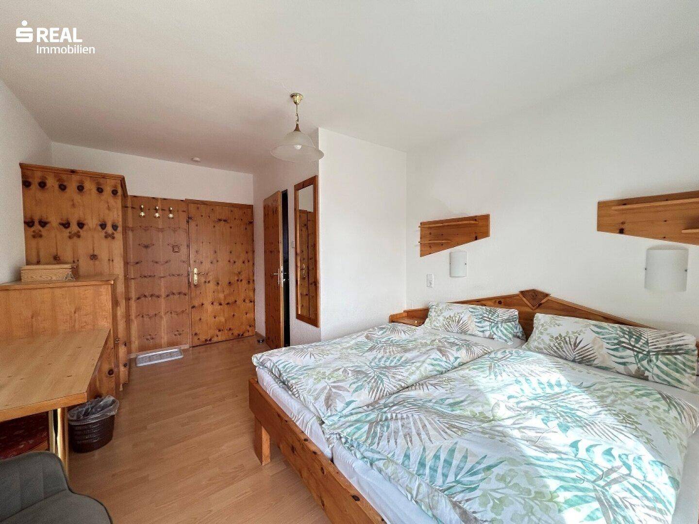 Geräumiges Schlafzimmer mit Doppelbett, Einbauschränken aus Holz und hellem Ambiente.