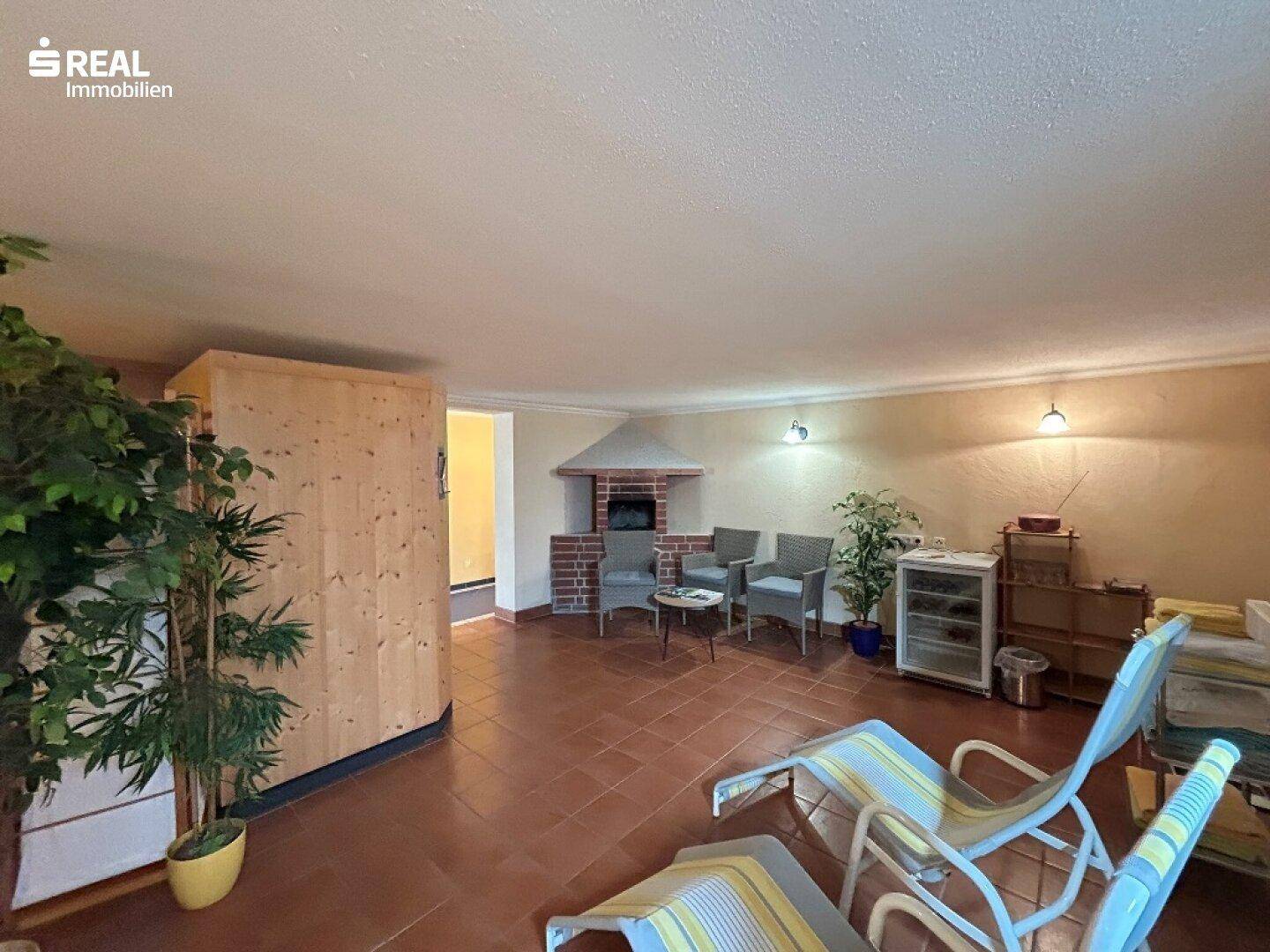 Entspannungsraum mit Liegestühlen, Kamin und Pflanzen.