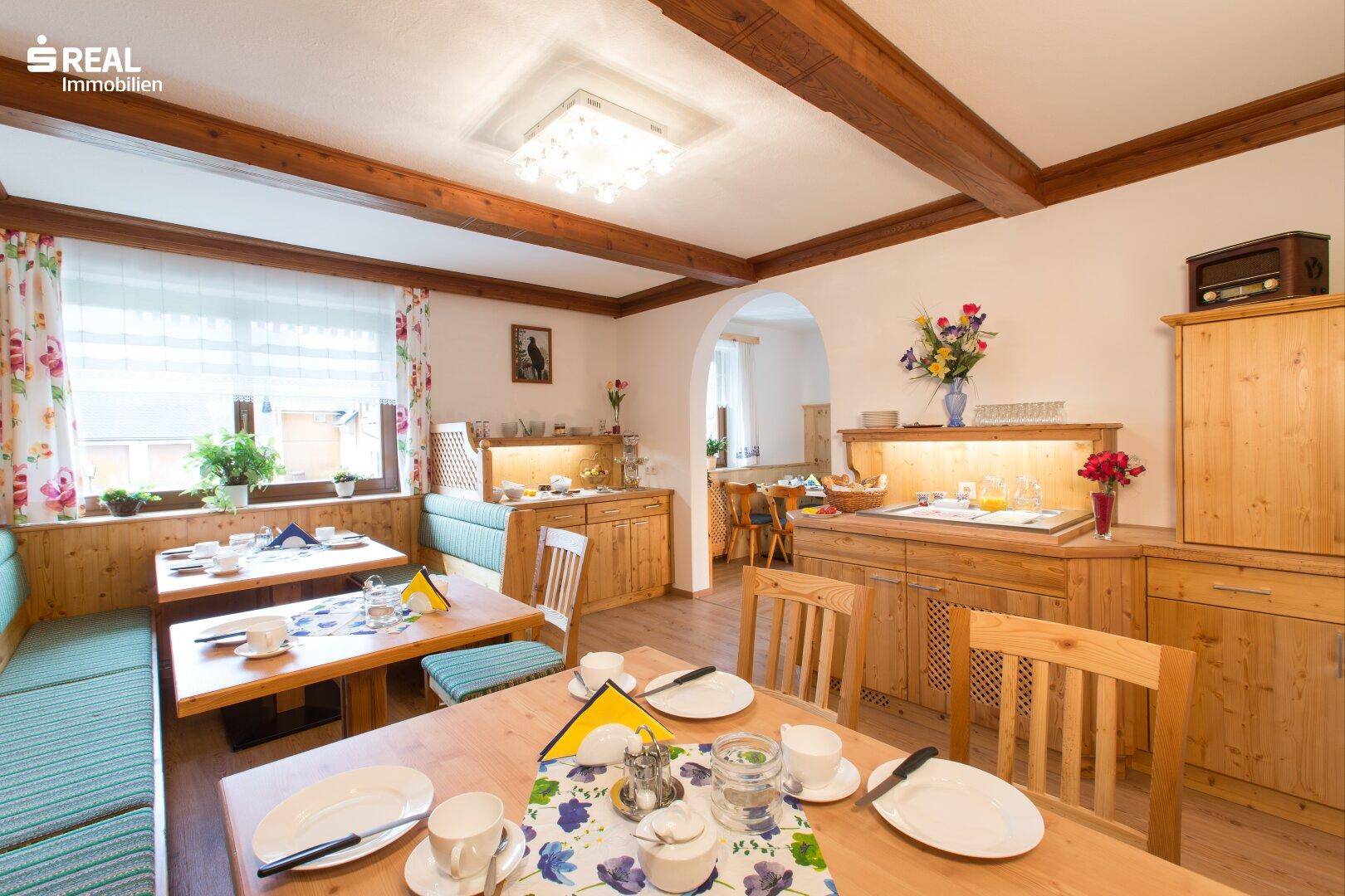 Gemütlicher Essbereich mit Holztischen, Bänken und Buffet, ideal für gemeinsame Mahlzeiten.