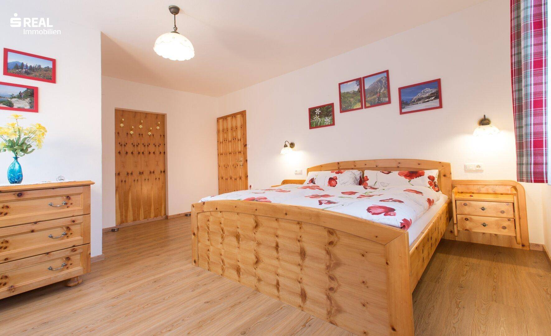 Helles Schlafzimmer mit traditionellen Holzmöbeln und weiß gestrichenen Wänden.