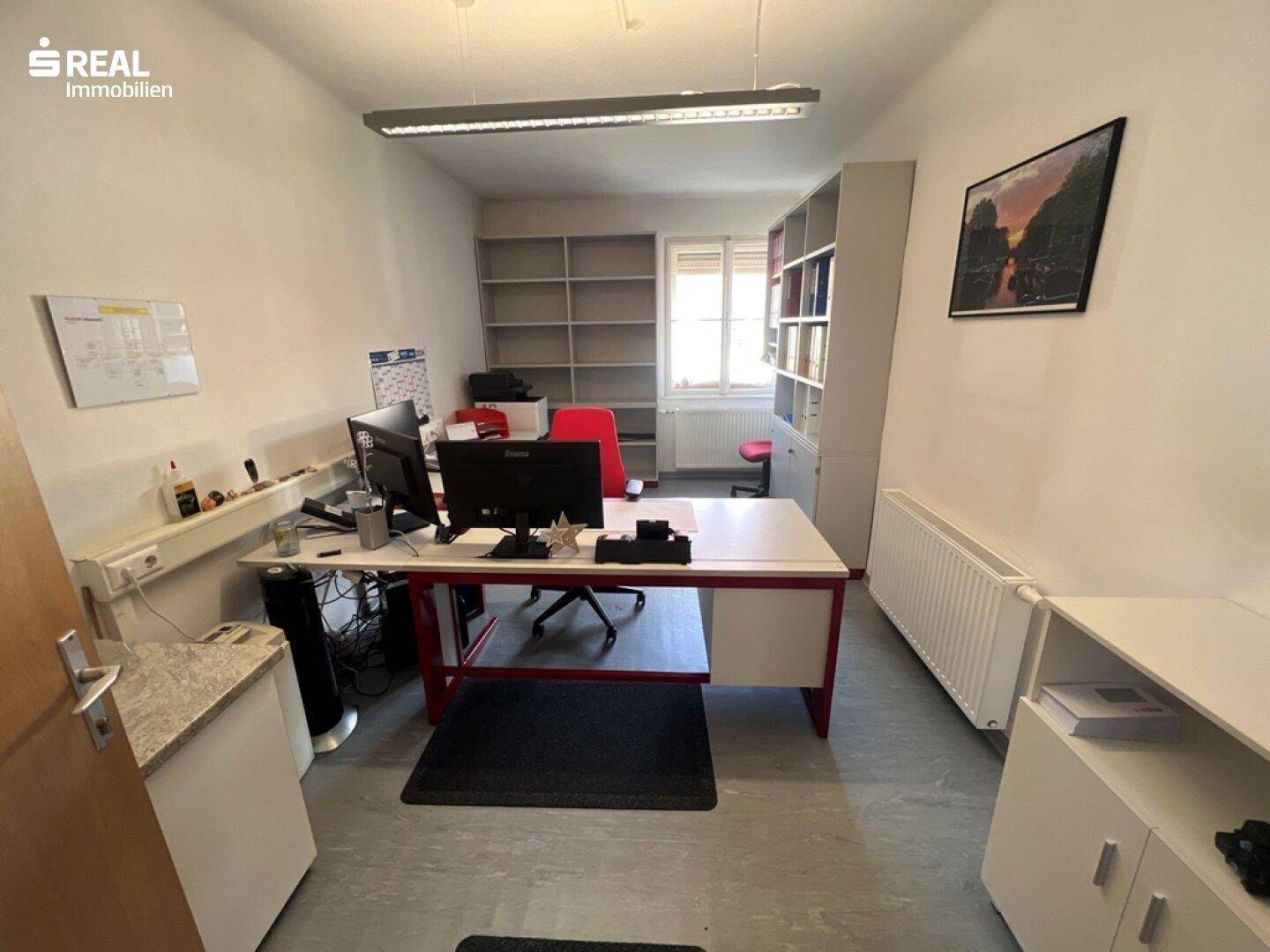 Einzelbüro mit Schreibtisch, Bürostuhl und Regalen, ausgestattet für konzentriertes Arbeiten.