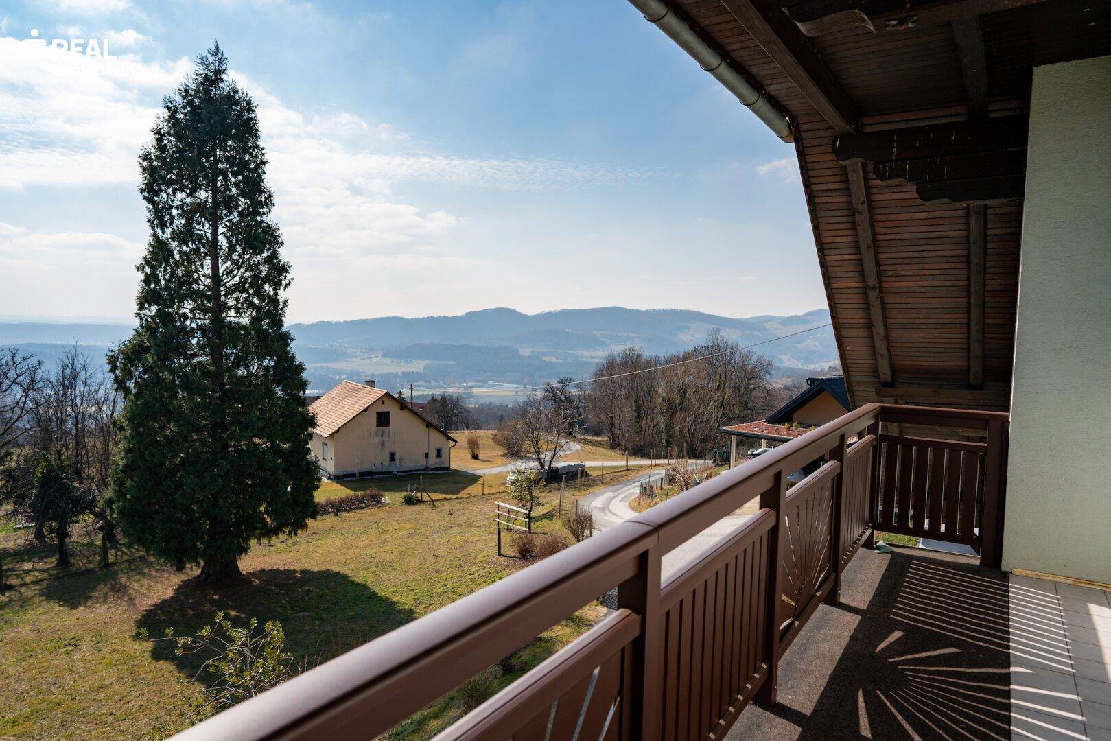 Balkon mit weitem Blick über die umliegende Landschaft und Berge.