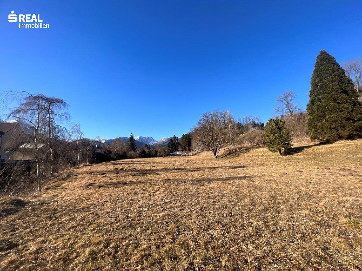 Großes Grundstück mit weitem Blick auf die Alpen und die umgebende Naturlandschaft.