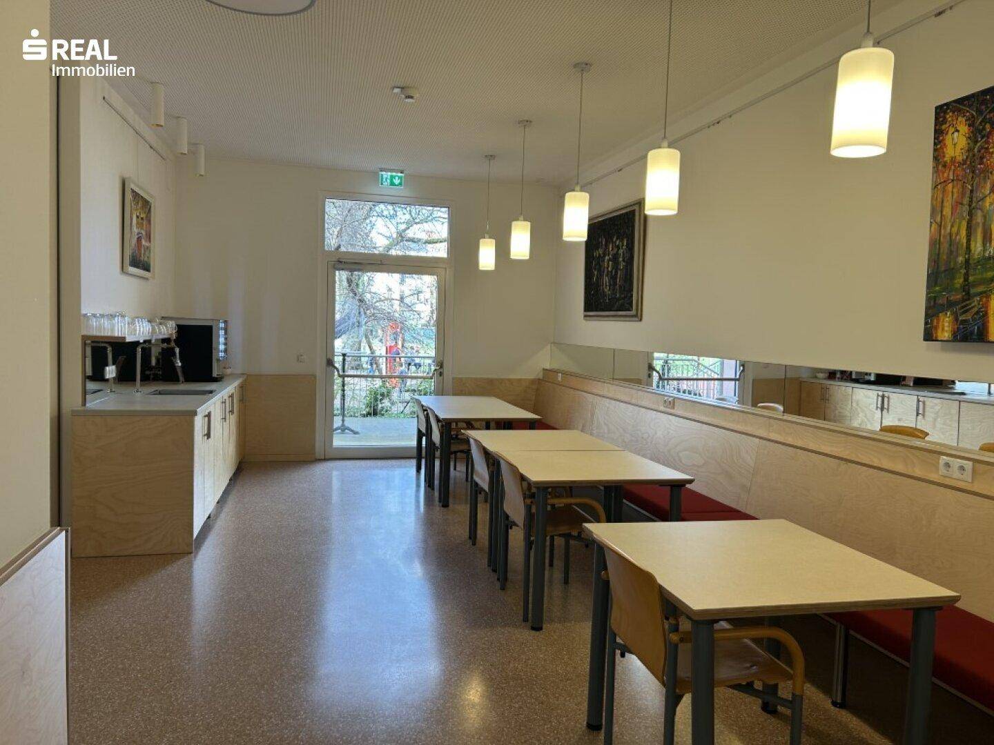Speisesaal mit Zugang zum Außenbereich, ausgestattet mit Tischen und Bänken für Gäste.