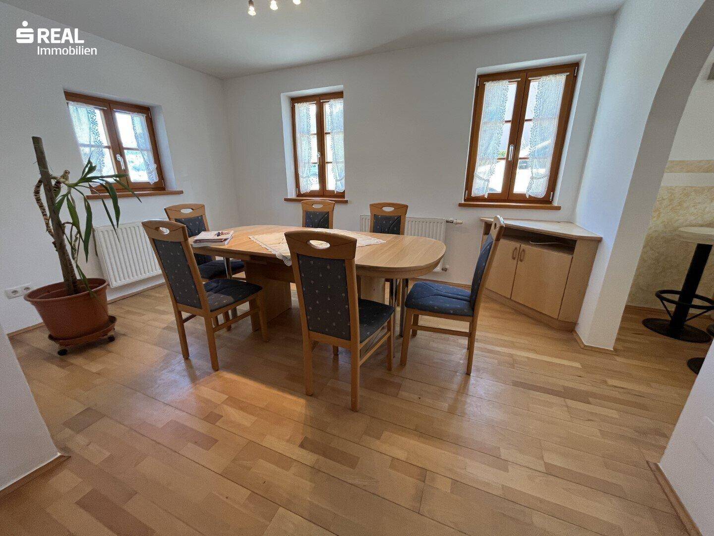 Heller Essbereich mit Holztisch, Stühlen und einem Sideboard, ideal für Familienmahlzeiten.