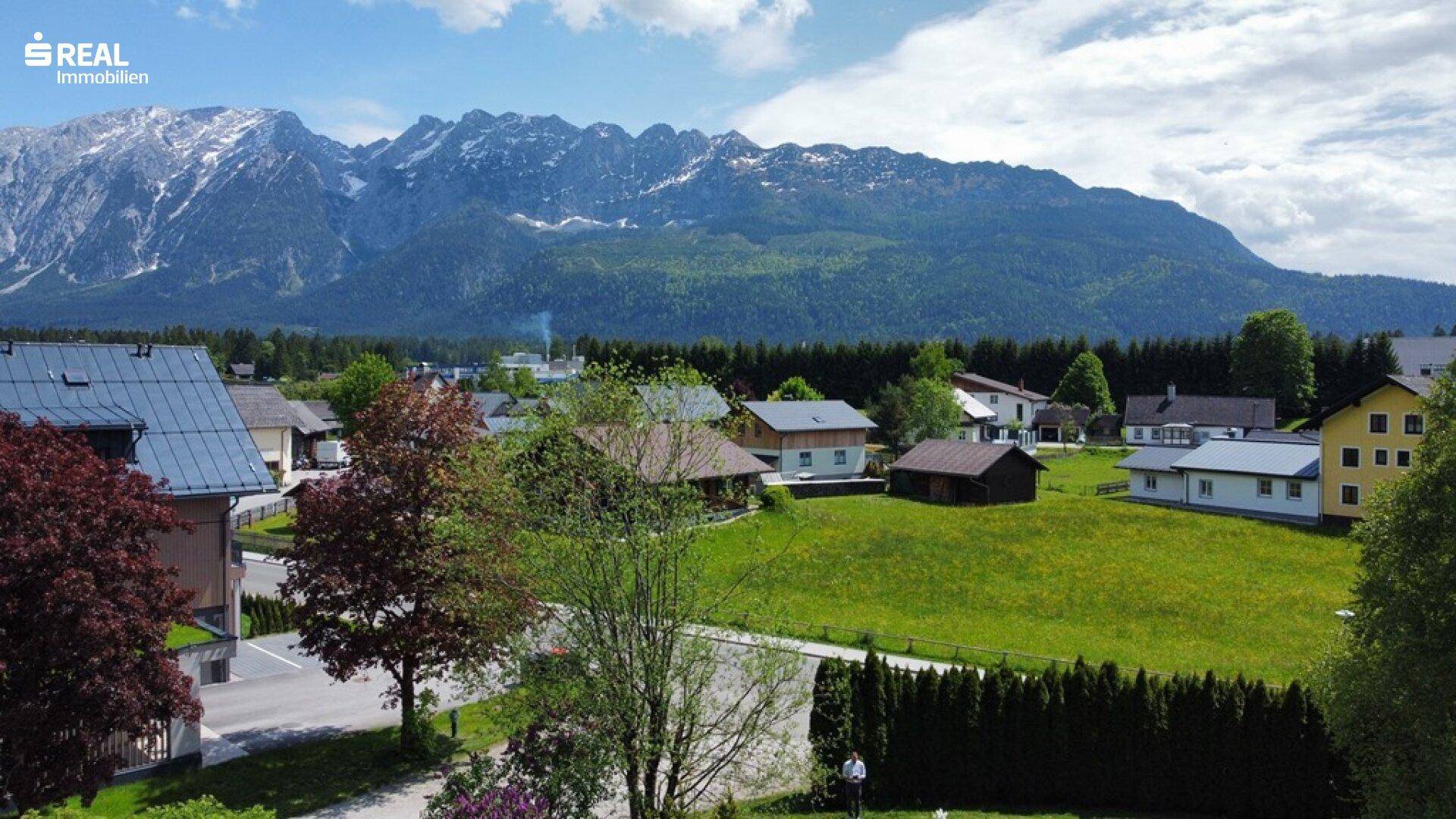 Weitläufiger Blick auf die umliegende Berglandschaft und das charmante Dorf.