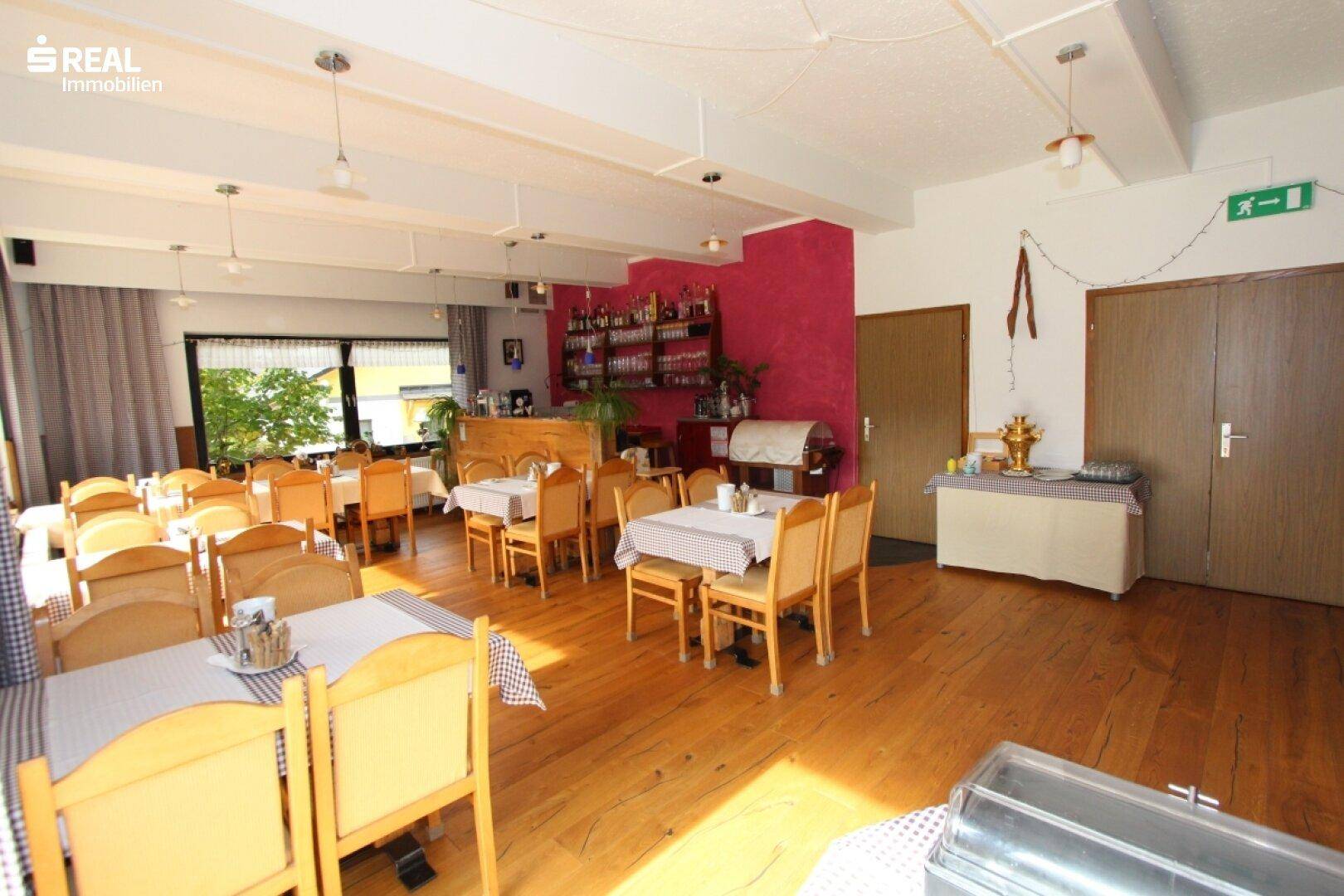Gemütlicher Speisesaal mit Bar, Holzboden und traditioneller Einrichtung.