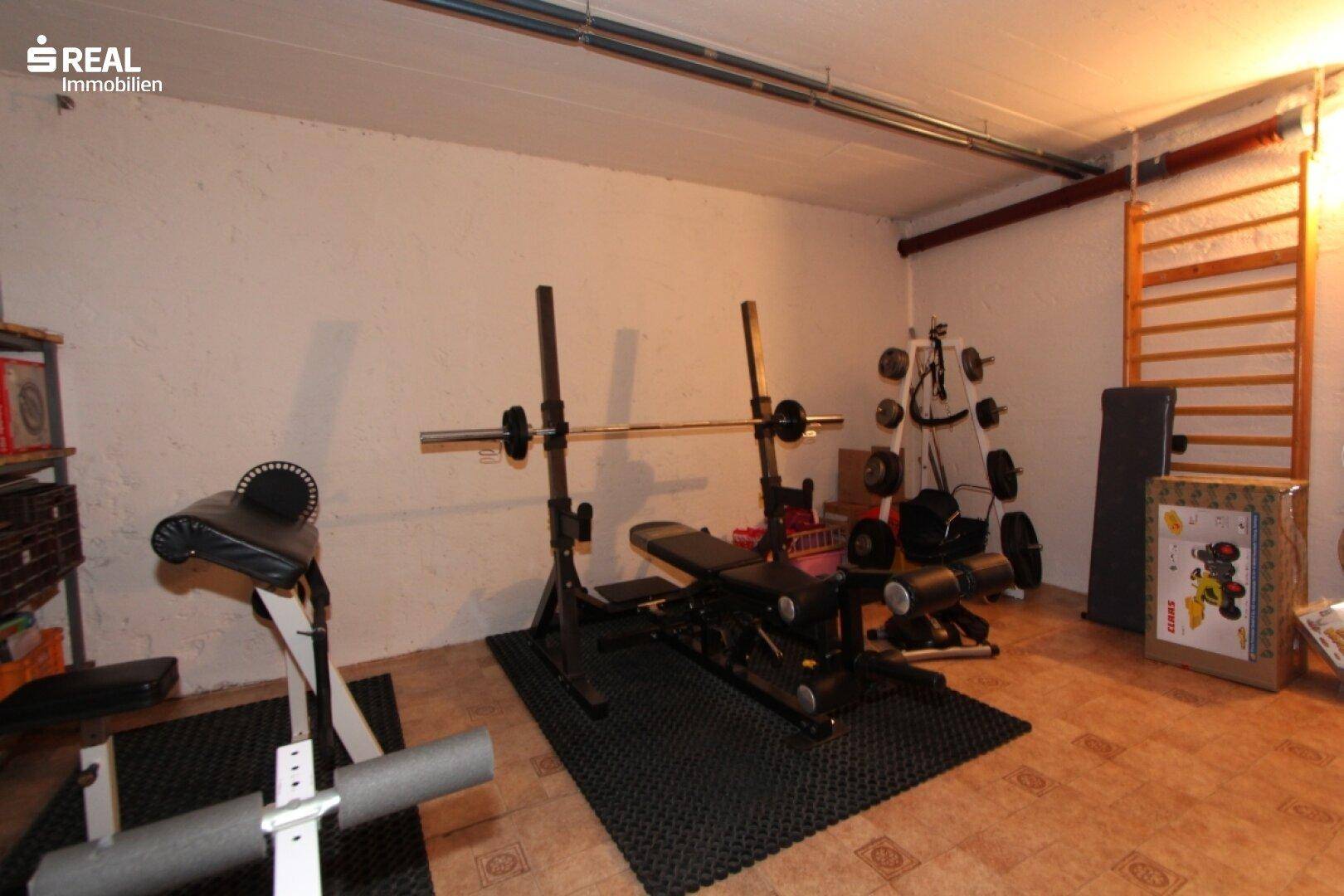 Fitnessraum mit verschiedenen Trainingsgeräten und Sprossenwand für Sportaktivitäten.