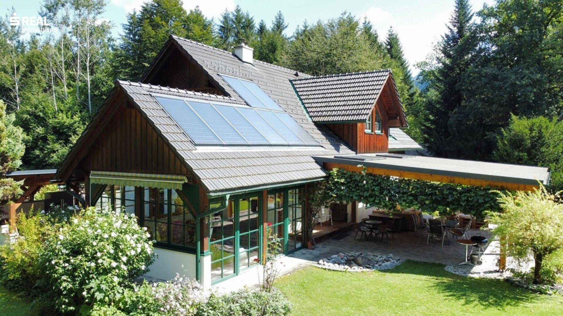Weitläufiges Anwesen mit Photovoltaikanlage, großem Garten und überdachter Terrasse mit Sitzbereich.