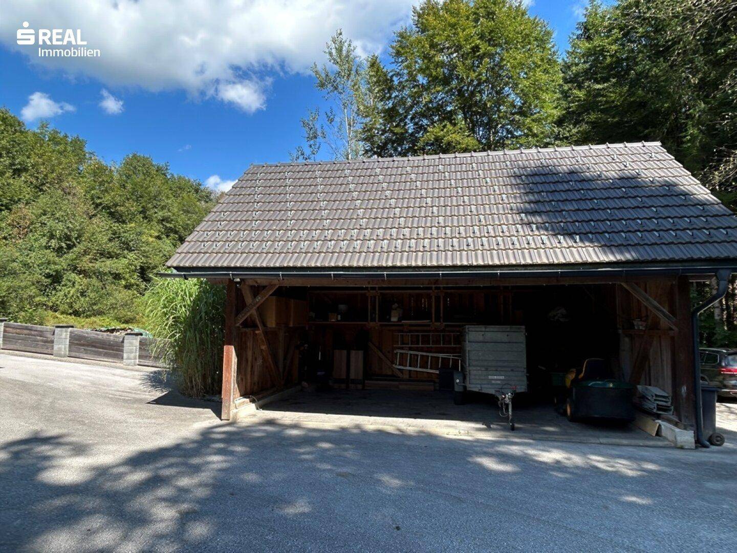 Geräumiger Holzcarport mit Satteldach, bietet Schutz für Fahrzeuge und Stauraum.