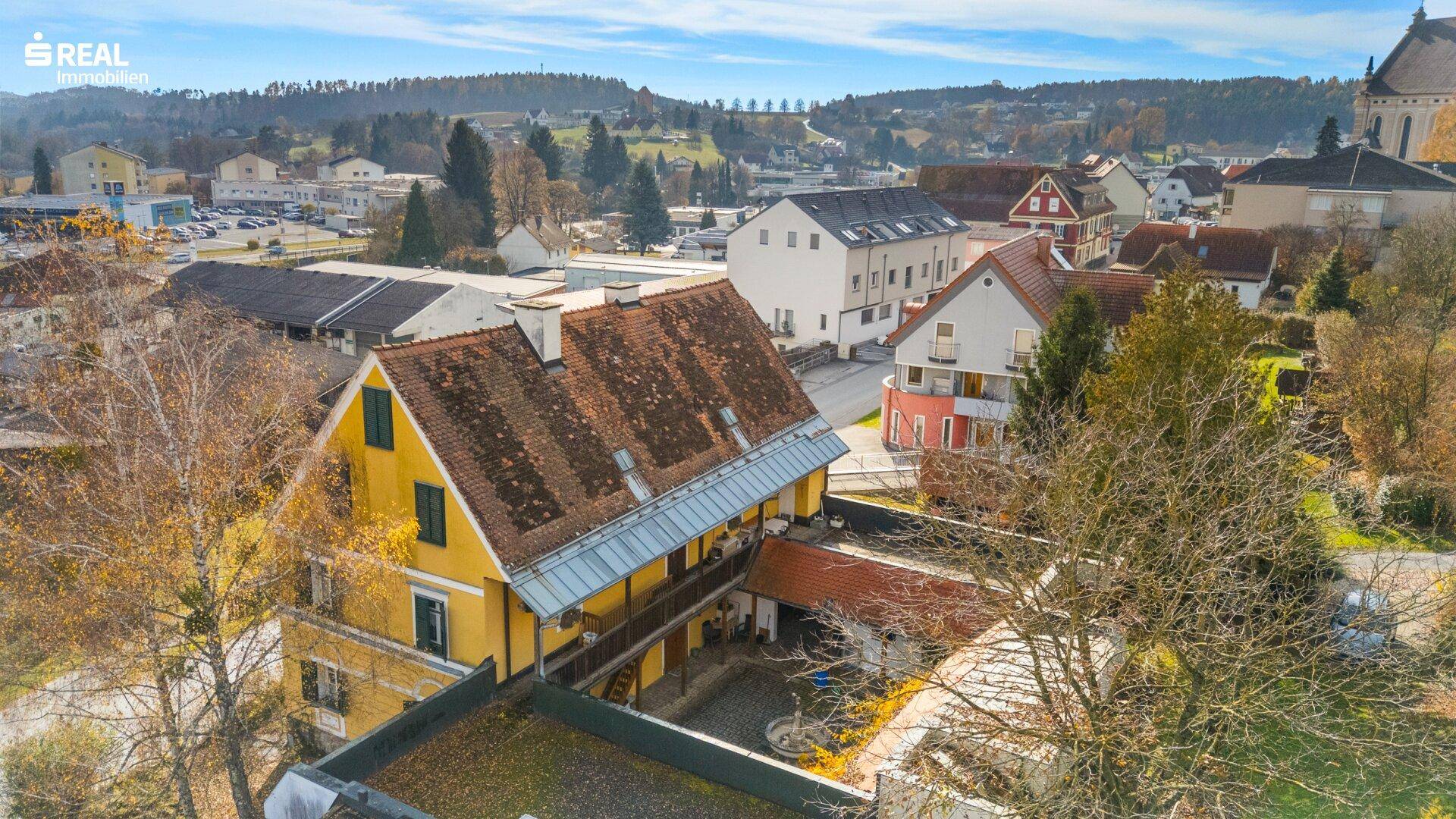 Rückansicht des historischen Gebäudes mit Innenhof und Blick über die umliegende Ortschaft.