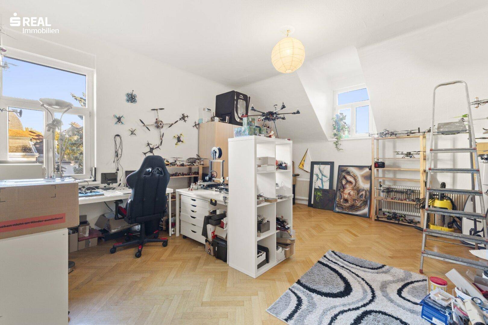 Geräumiges Arbeitszimmer im Dachgeschoss mit Schreibtischen und viel Tageslicht.