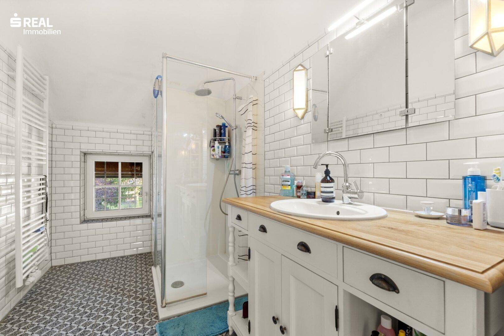 Modernes Badezimmer mit begehbarer Dusche, Holzwaschtisch und Fenster.