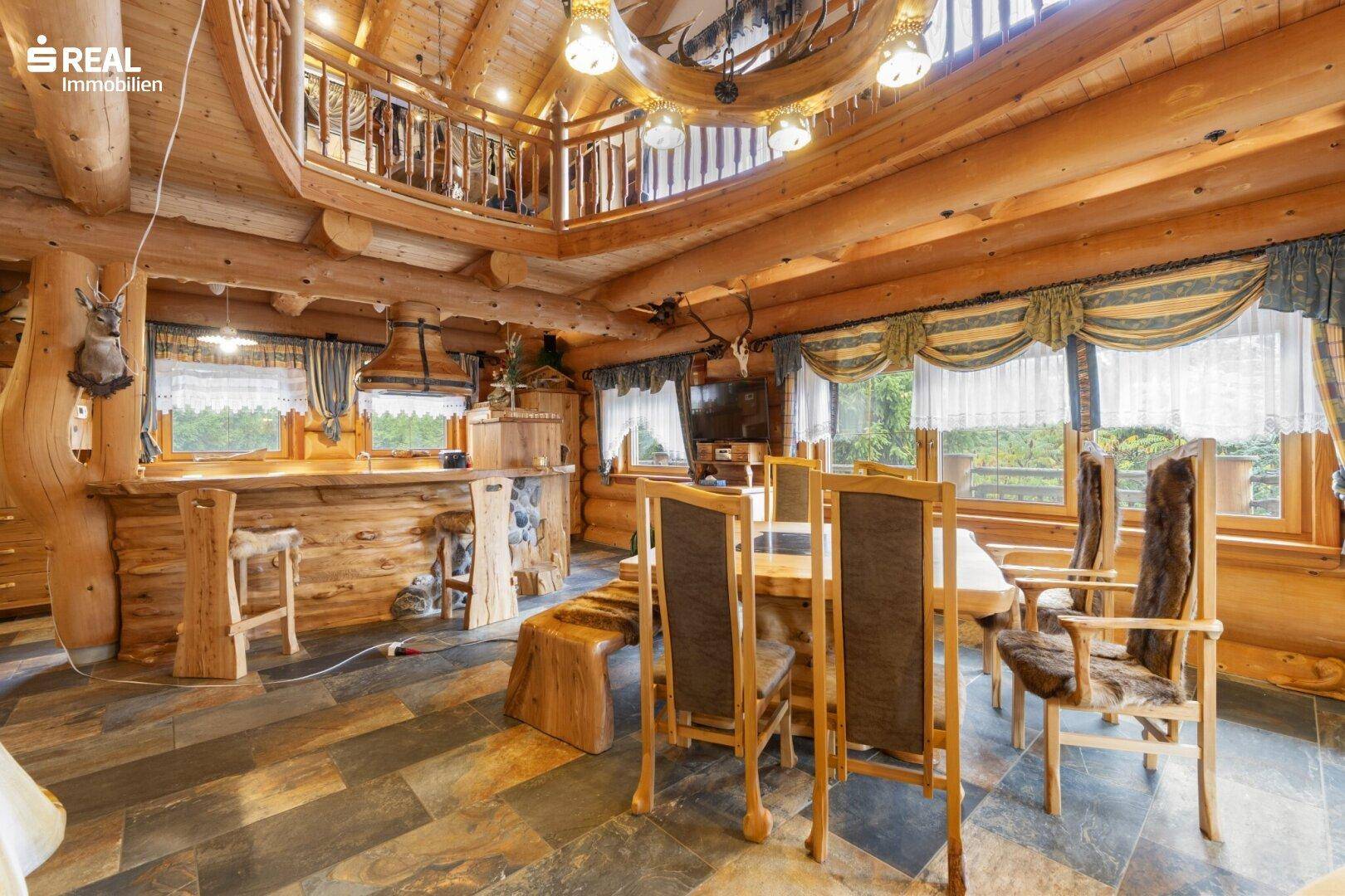 Rustikaler Wohn- und Essbereich in einem Holzhaus mit Bar und Galerie.