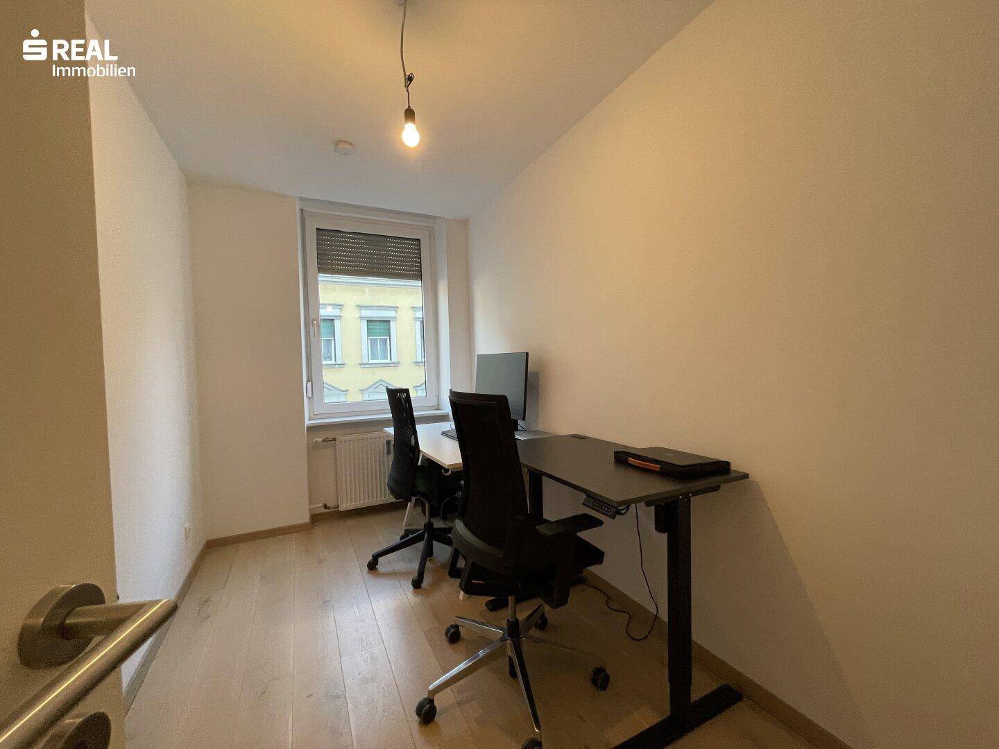 Helles Büro mit zwei Schreibtischen und Bürostühlen, ideal für Home-Office.