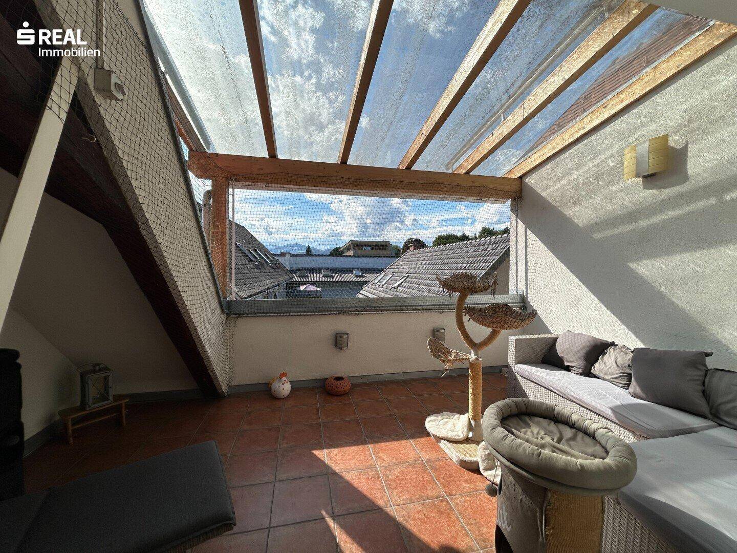 Überdachte Terrasse mit Sitzgelegenheiten und Blick auf die Umgebung, ideal zum Entspannen.