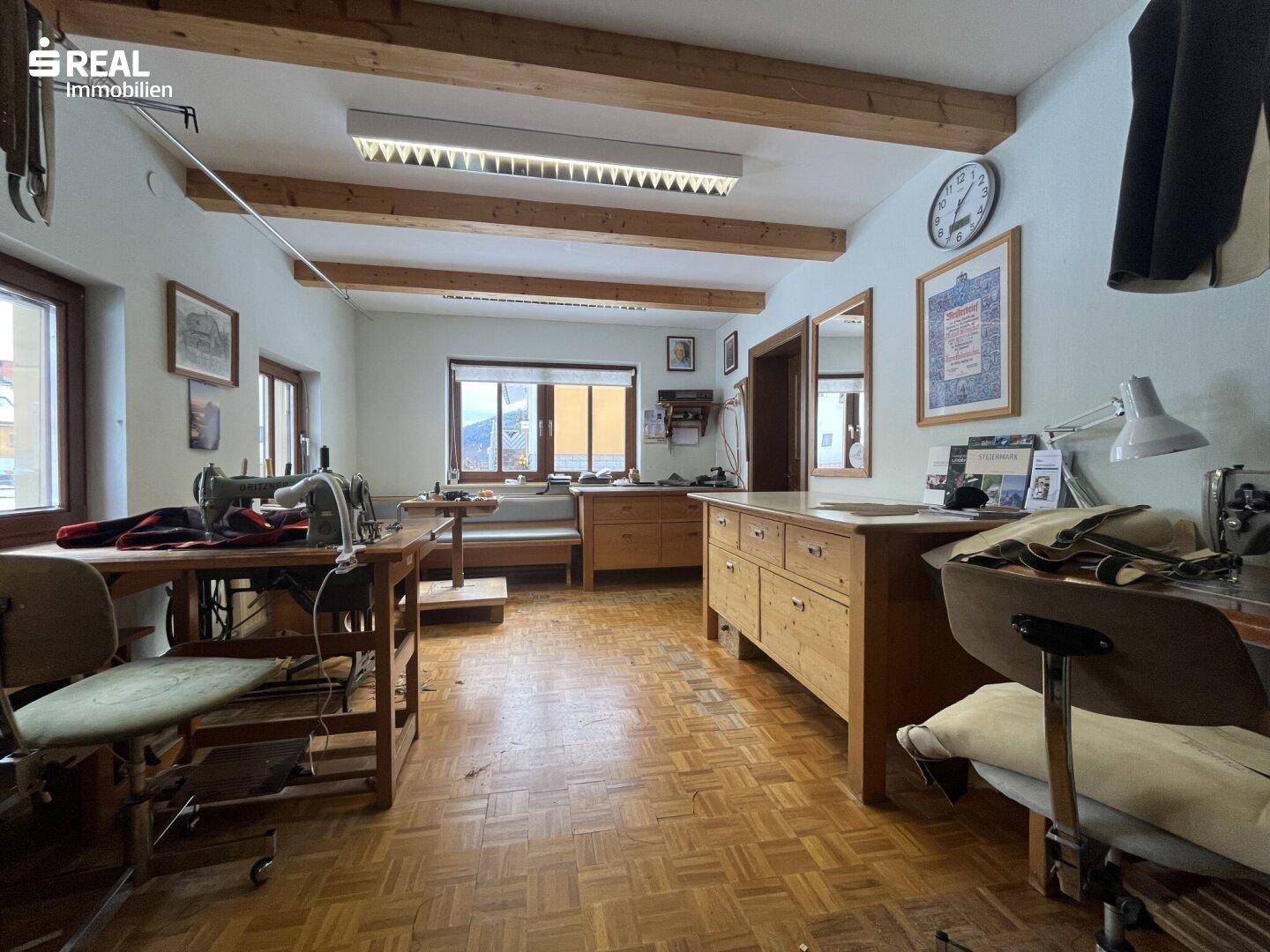 Geräumiger Arbeitsraum mit Holzboden und mehreren Nähmaschinen, ideal für kreative Tätigkeiten.