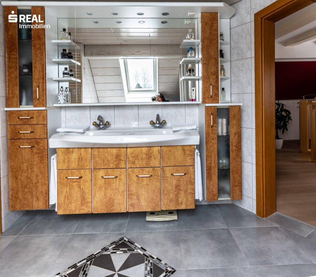 Modernes Badezimmer mit Doppelwaschbecken, Spiegelschrank und Fliesenboden.