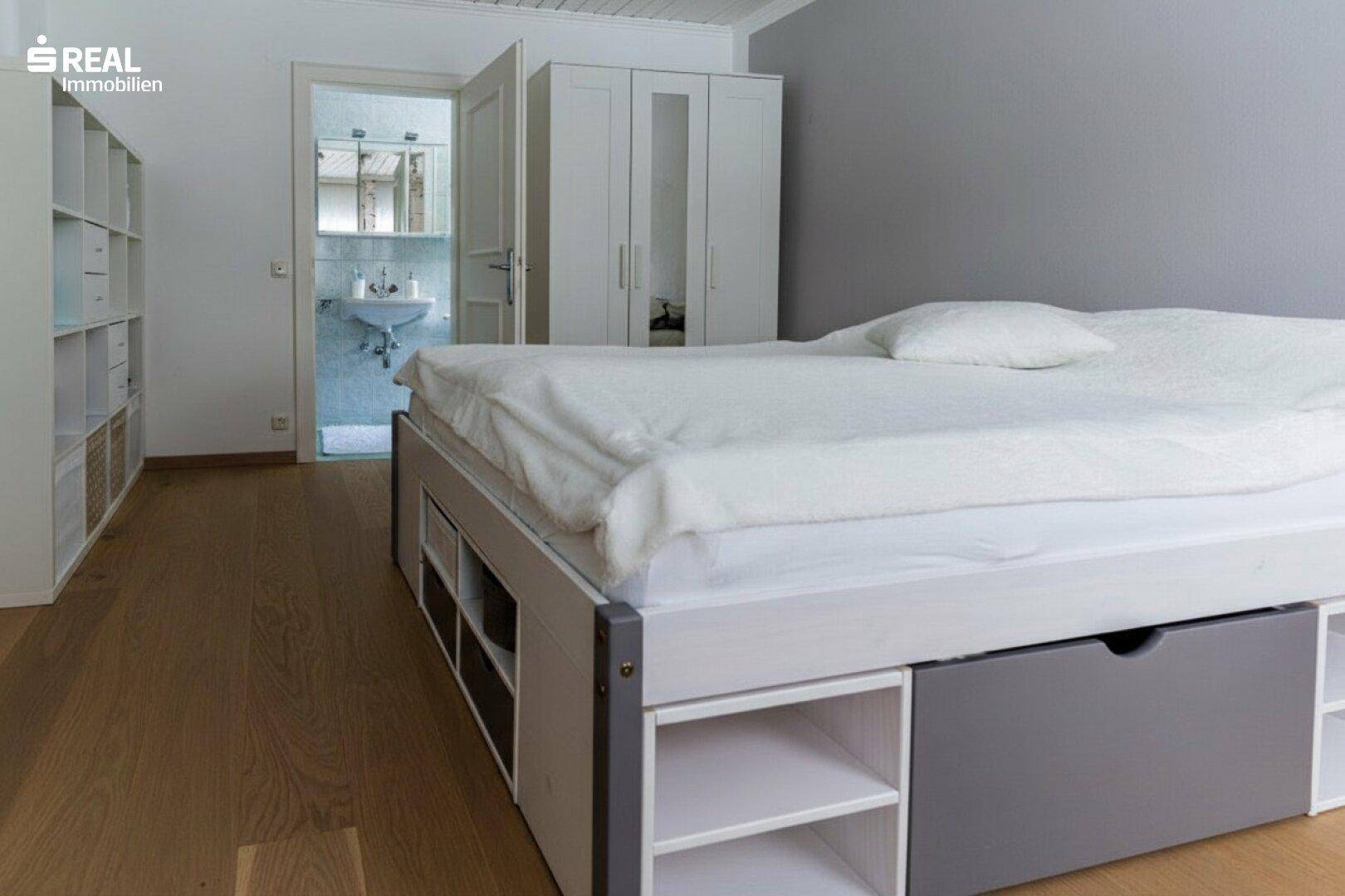 Gemütliches Schlafzimmer mit Bett, Kleiderschrank und Holzboden.