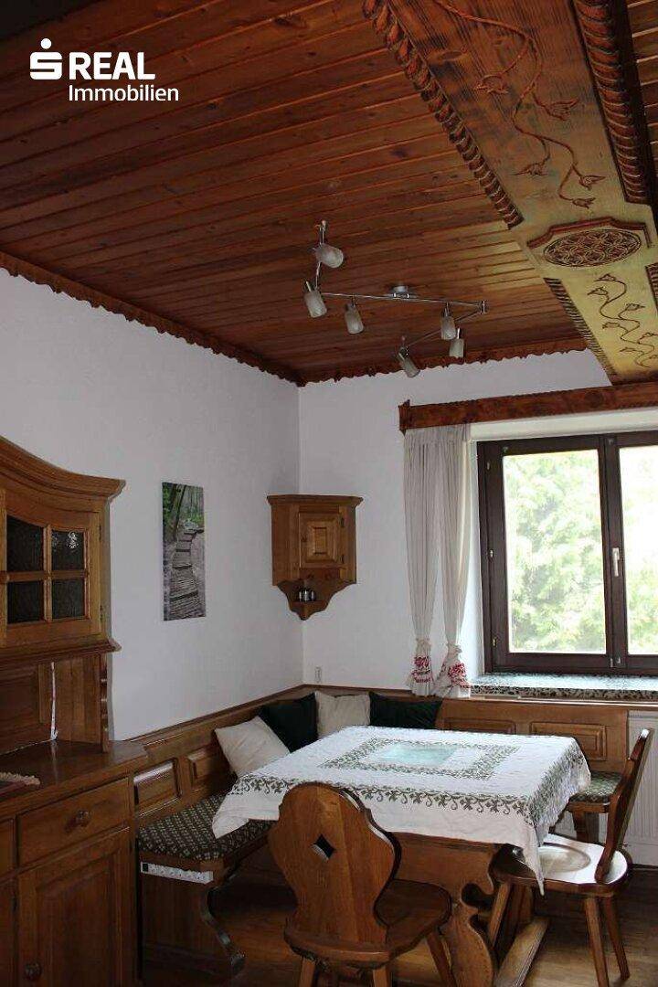 Gemütlicher Essbereich mit holzgetäfelter Decke, Eckbank und traditionellen Möbeln.