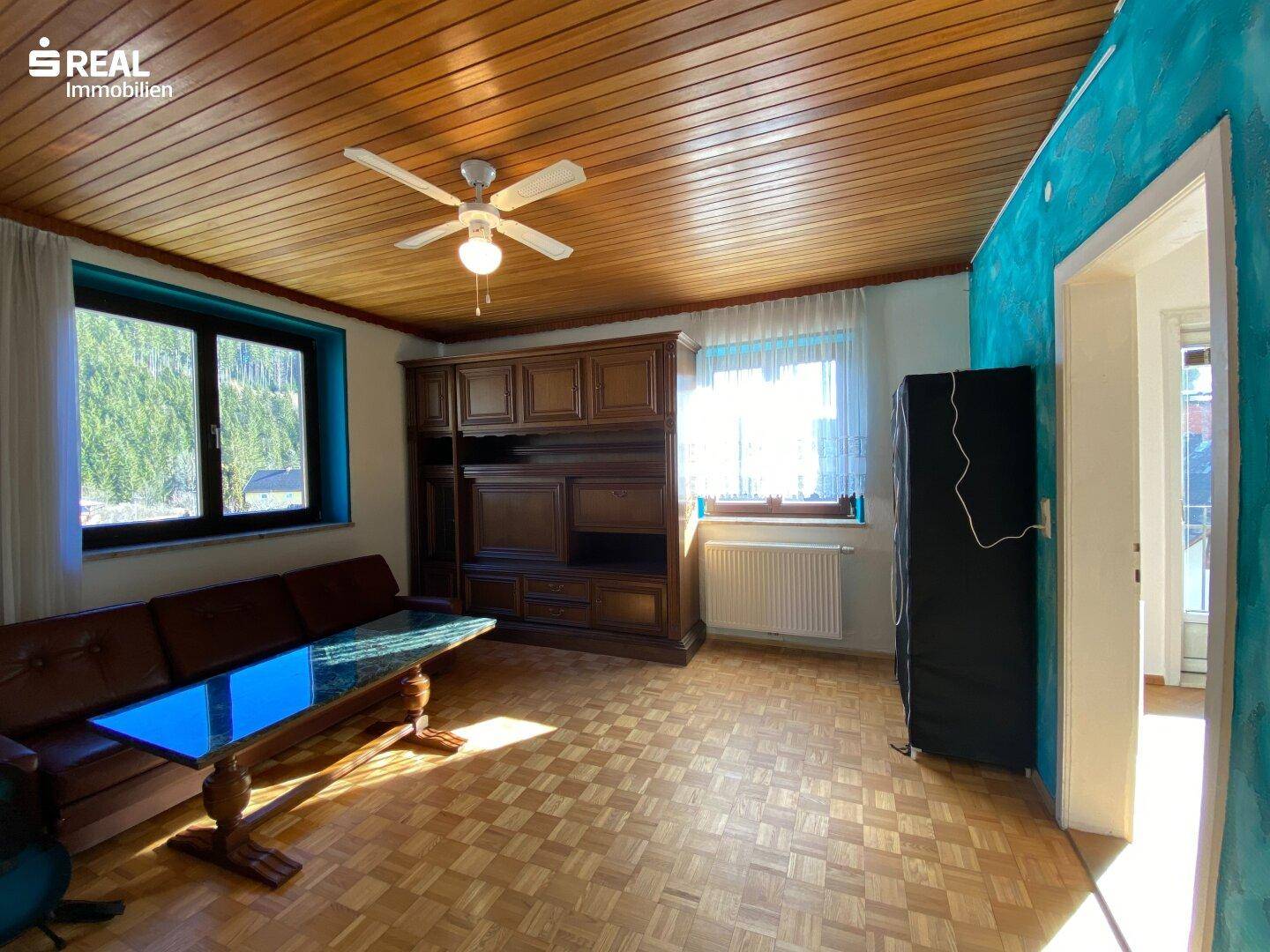Rustikales Wohnzimmer mit Holzdecke, Parkettboden und traditionellen Holzmöbeln.