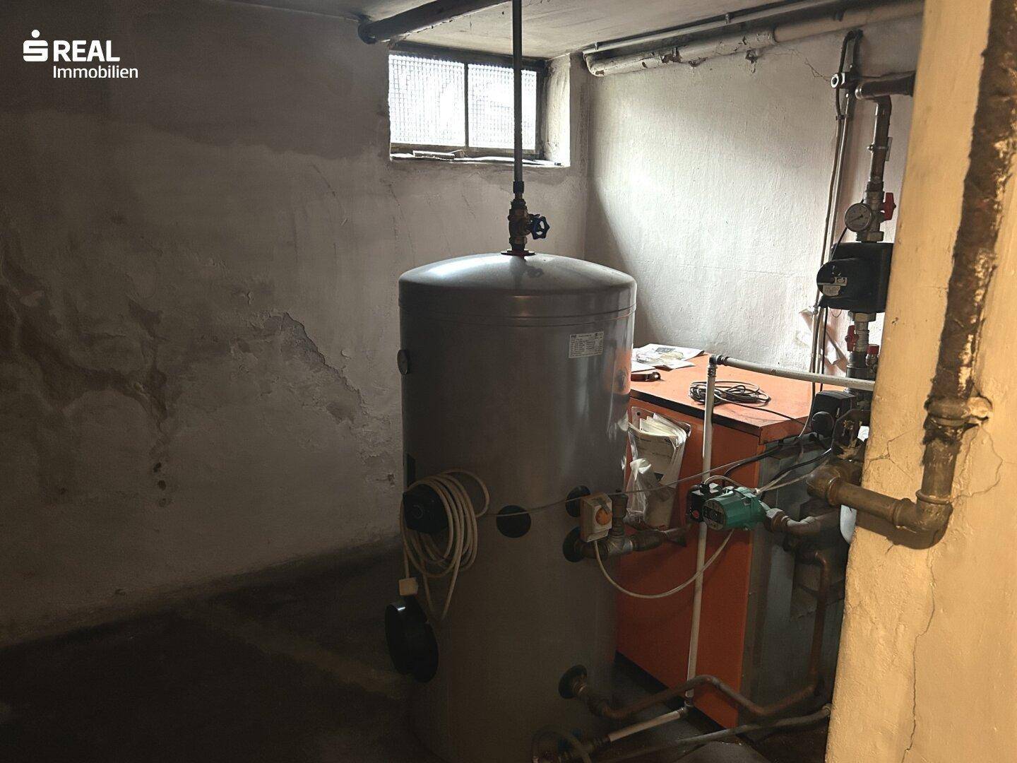 Heizungsraum im Keller mit Warmwasserspeicher und Heizungsanlage.