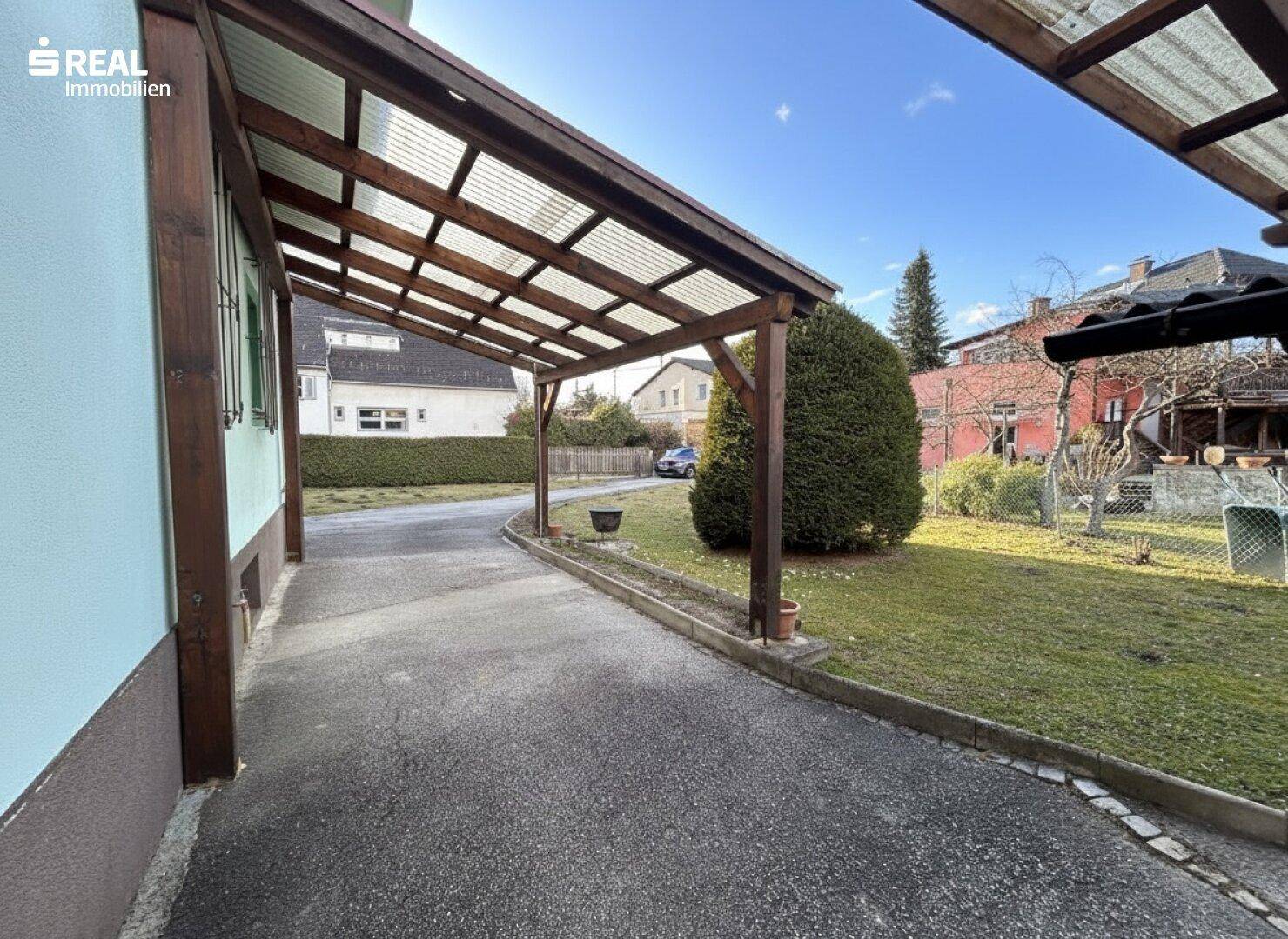 Überdachter Stellplatz (Carport) mit Zufahrt zum Haus.