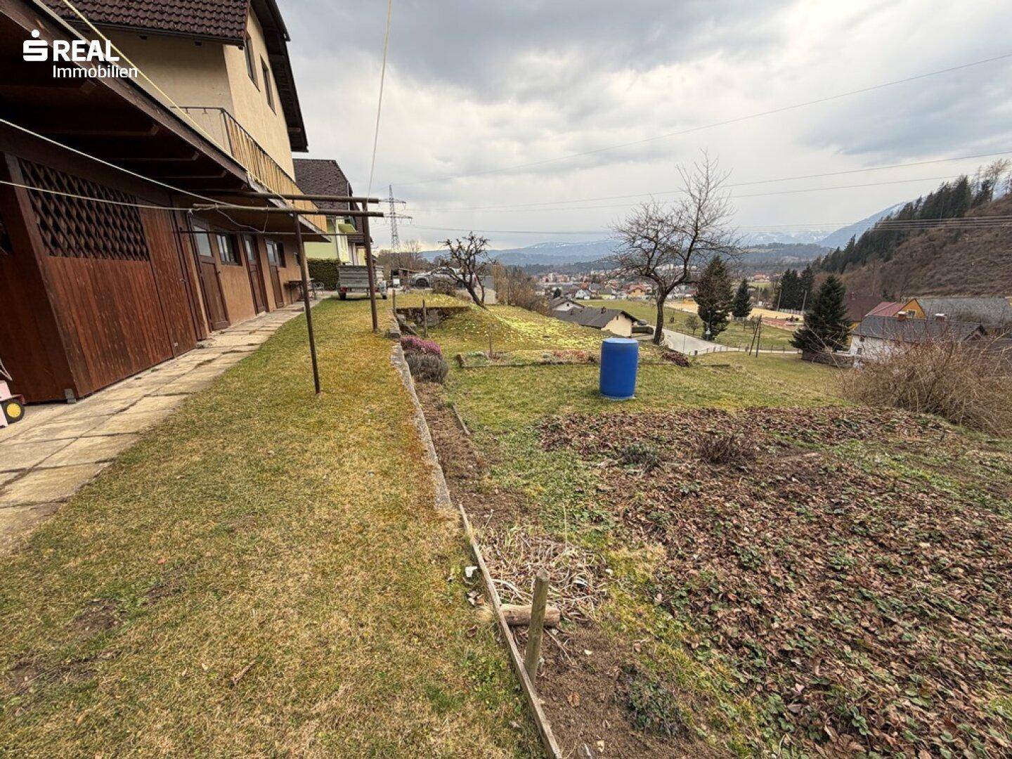 Großer Gartenbereich mit Rasenfläche und Blick auf die umliegende ländliche Umgebung.