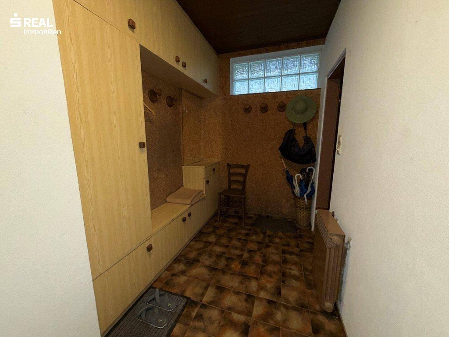 Eingangsbereich mit praktischen Einbauschränken und rustikalen Fliesen, ideal für Garderobe.
