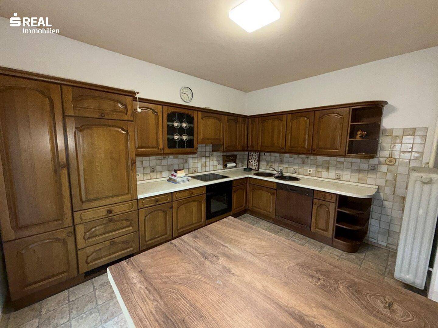 Geräumige Holzküche mit viel Stauraum und integrierten Geräten, ideal für Familien.