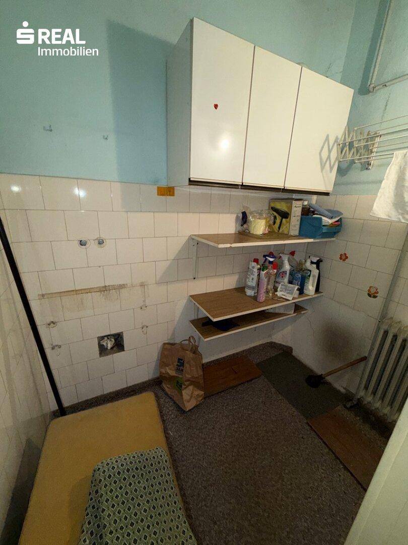 Hauswirtschaftsraum mit Regalen und Anschlüssen, ideal für Waschmaschine und Lagerung.