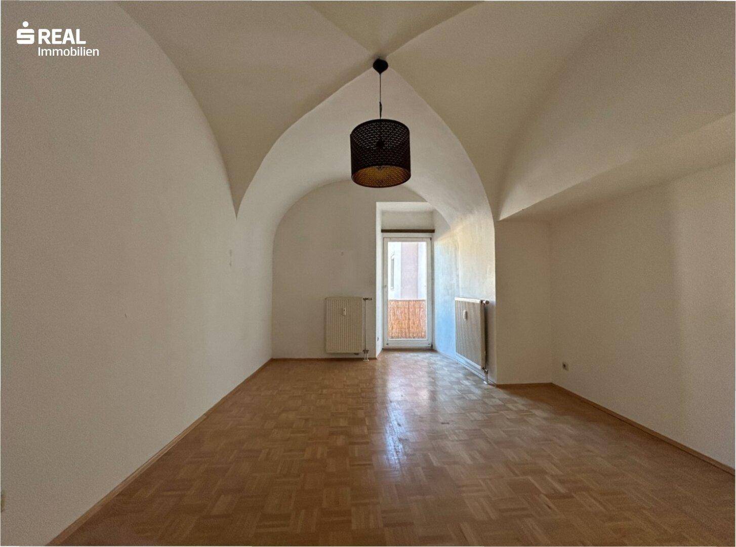 Heller Raum mit einzigartiger Gewölbedecke und Parkettboden, ideal als Wohn- oder Schlafzimmer.