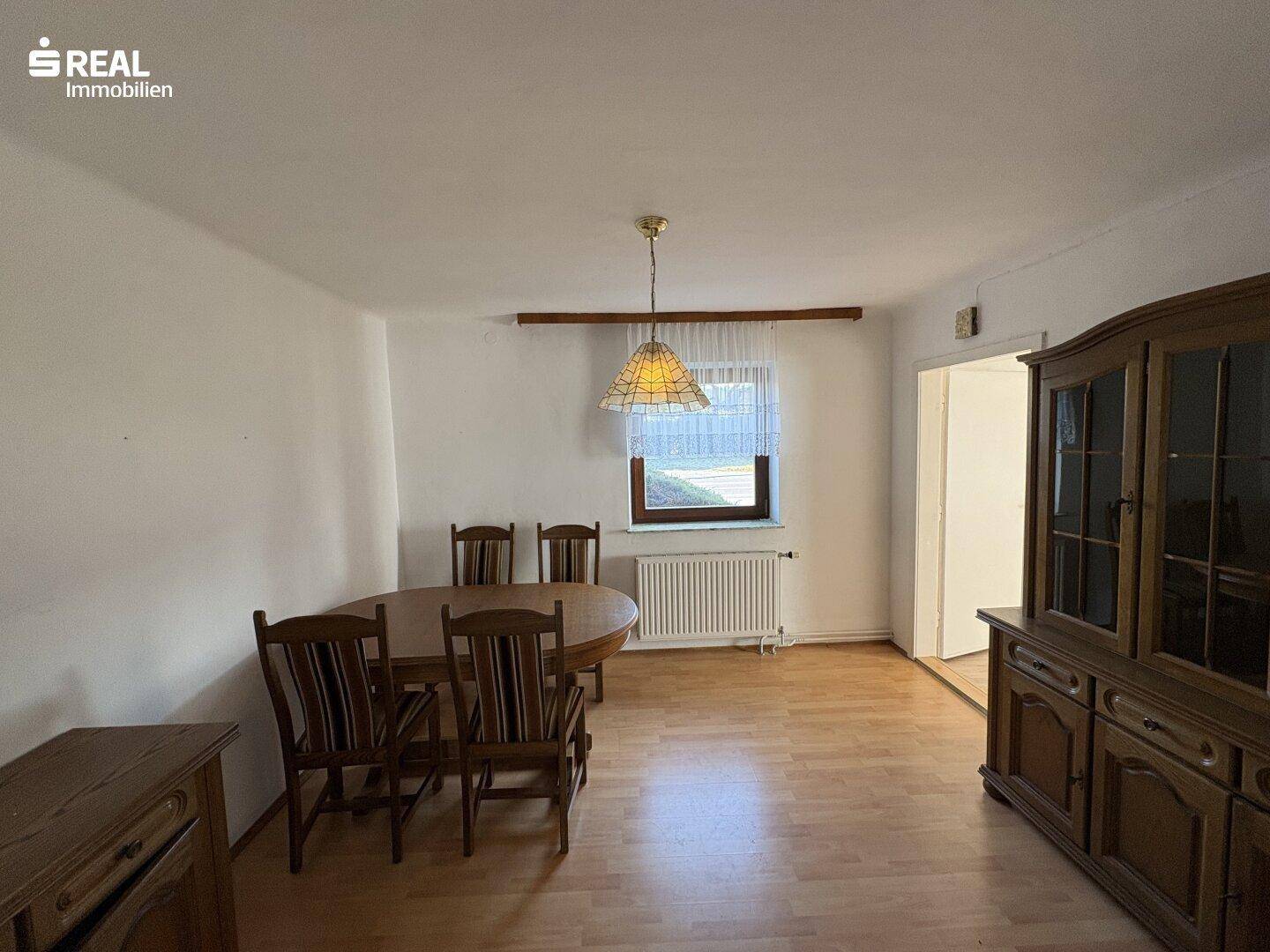 Geräumiger Essbereich mit Holztisch, Stühlen und Laminatboden in hellem Ambiente.