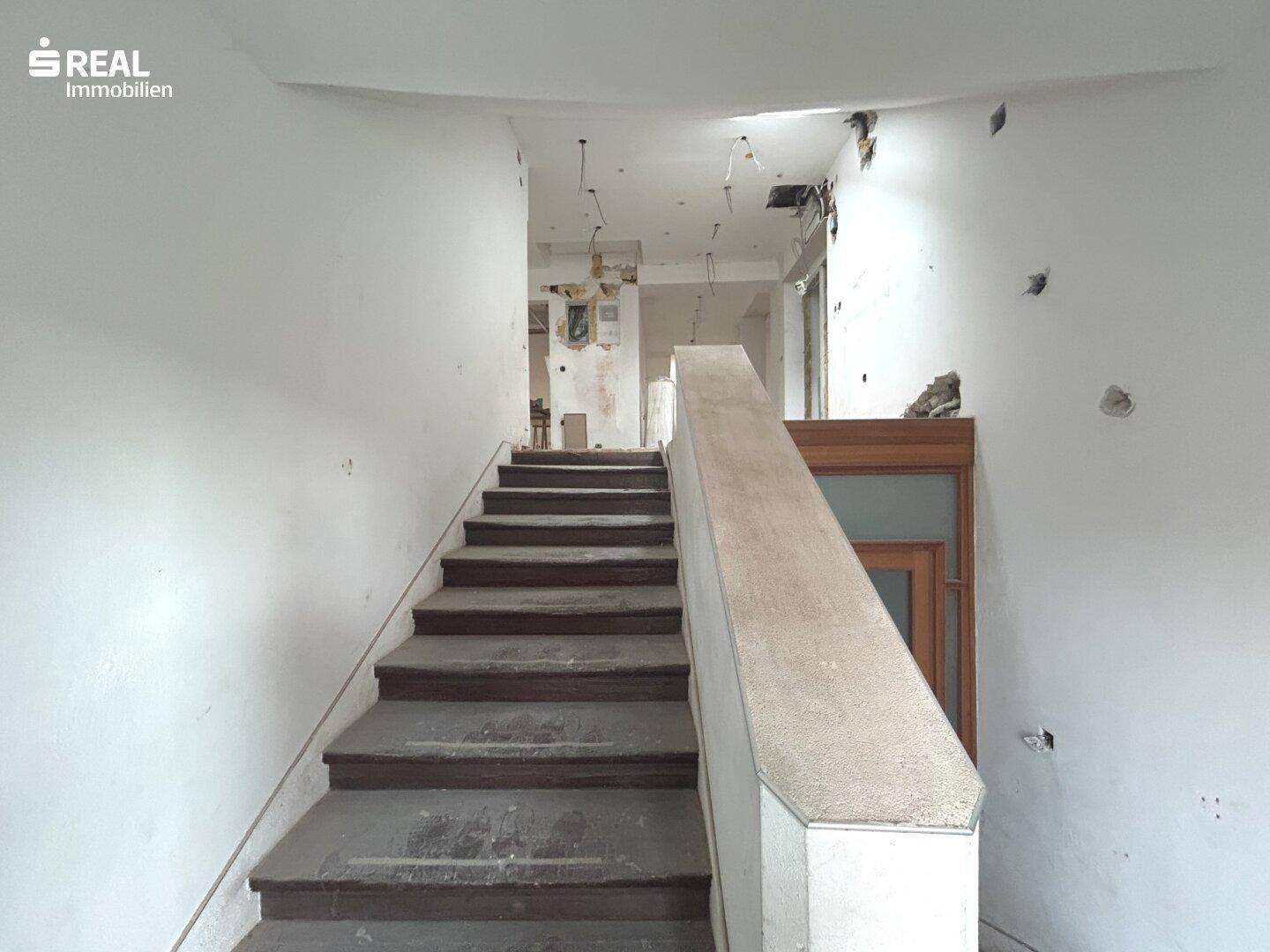 Treppenhaus in einem Gebäude unter Renovierung mit sichtbaren Spuren des Umbaus.