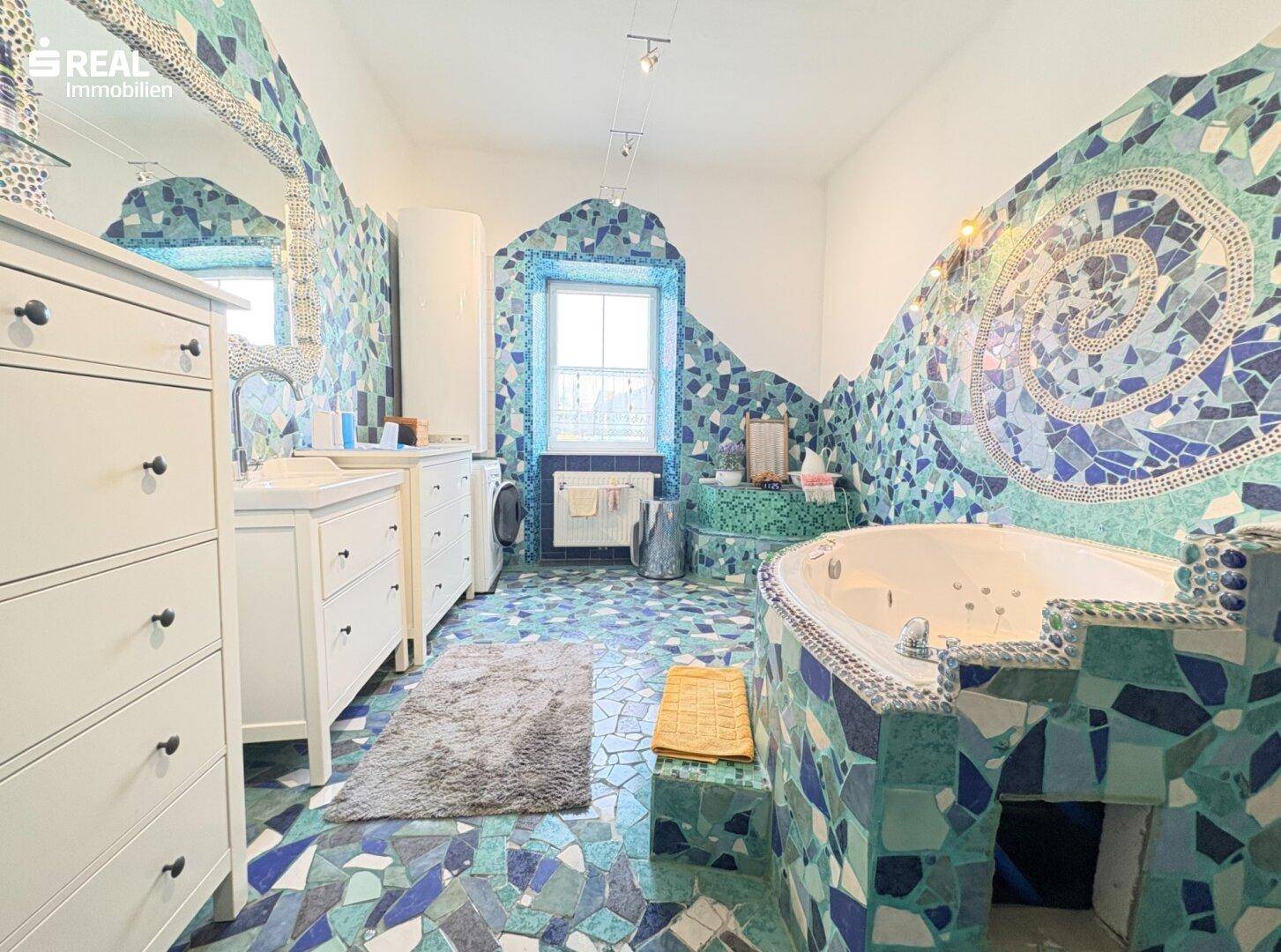 Einzigartiges Badezimmer mit Mosaikfliesen, Whirlpool-Badewanne und Doppelwaschbecken.
