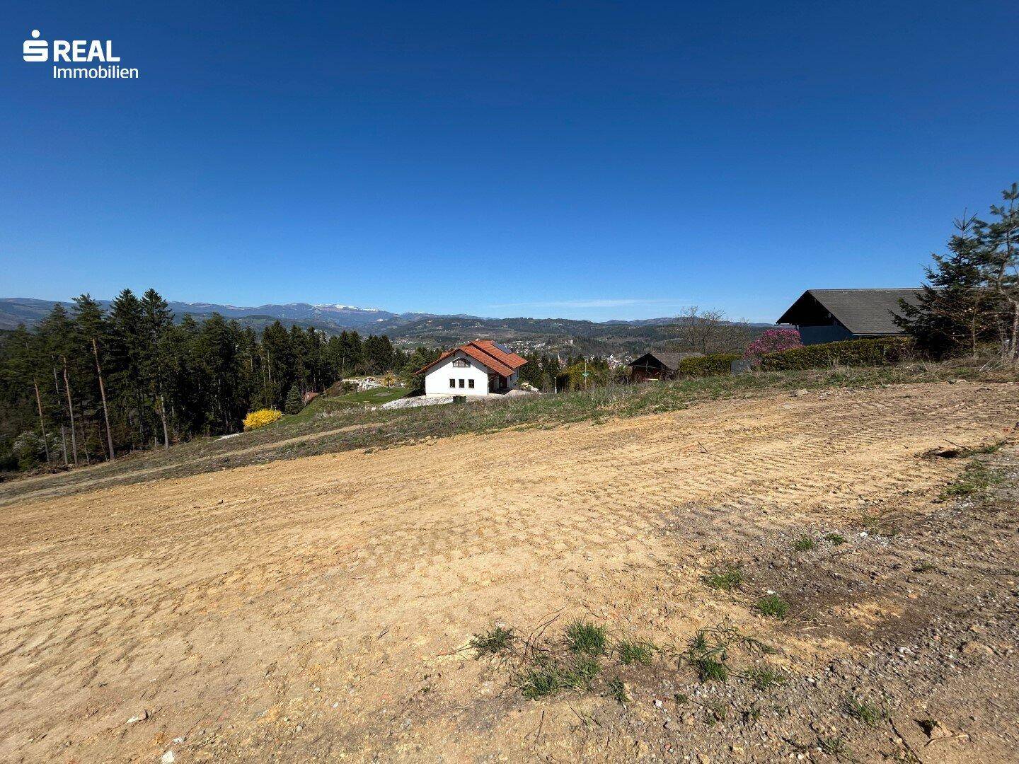 Weitläufiges Grundstück mit freiem Blick auf die Landschaft und die fernen Berge.