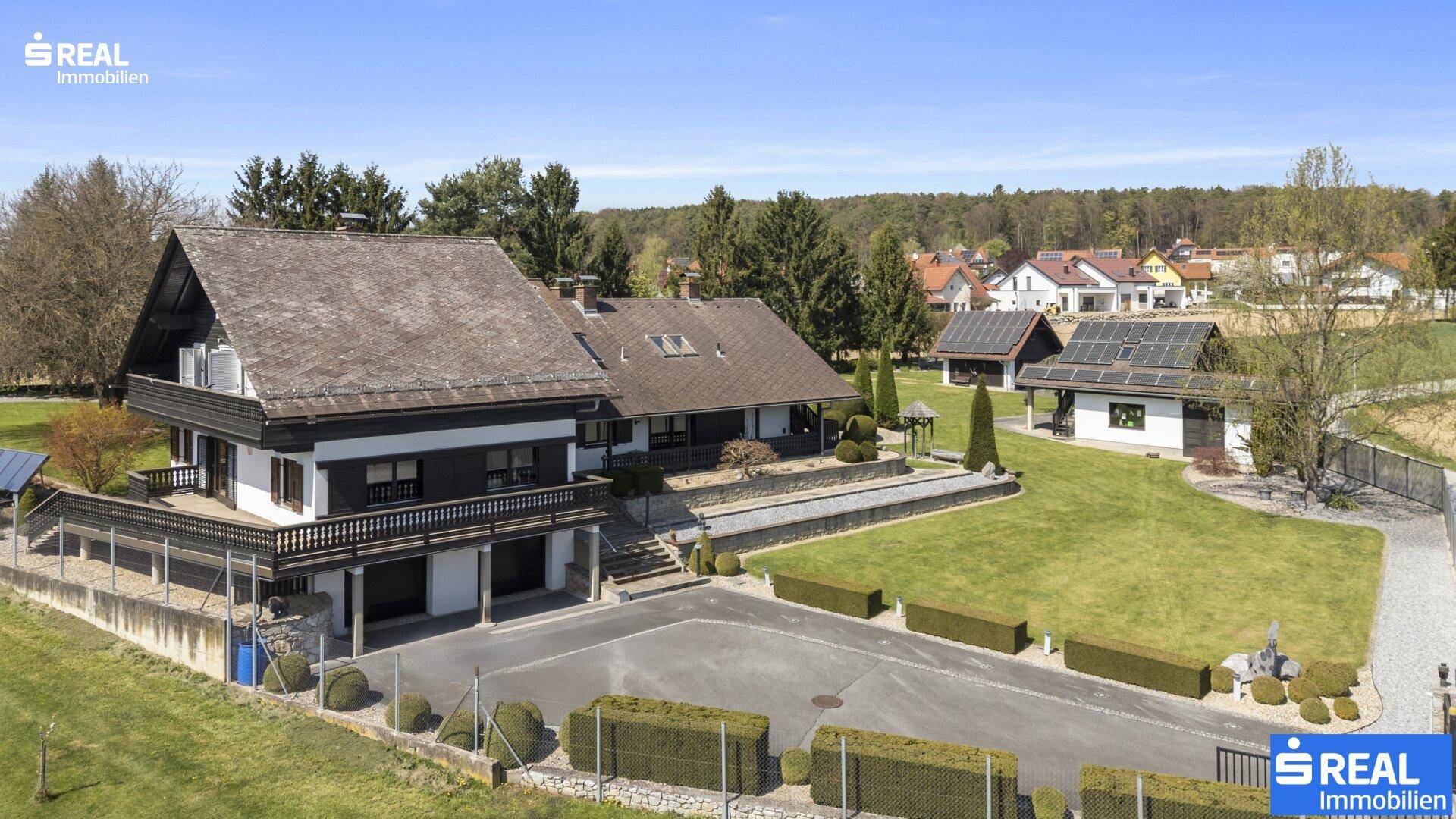 Großzügiges Anwesen mit Haupthaus, Nebengebäude und Photovoltaikanlage auf dem Dach.