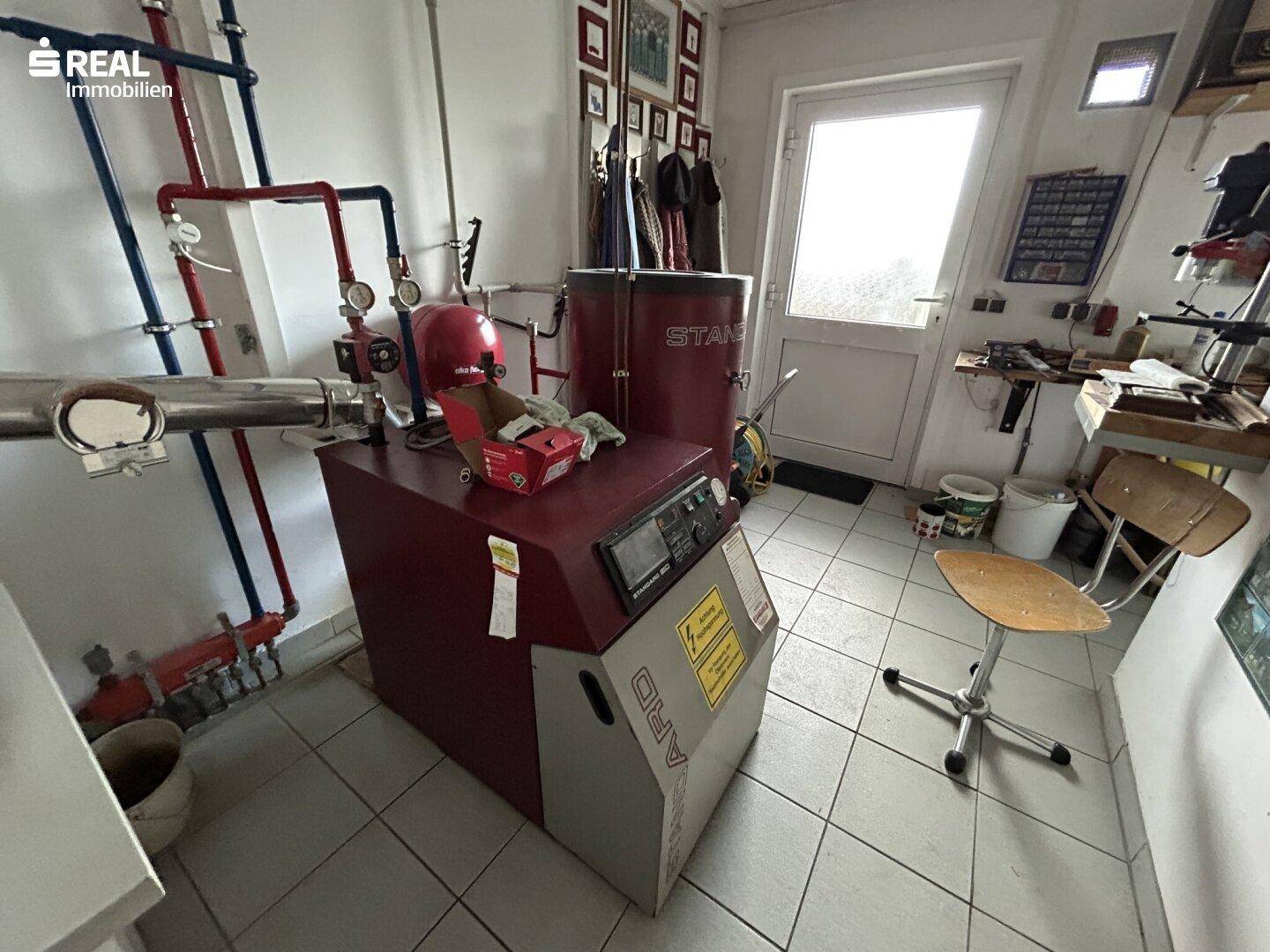 Heizungsraum mit Heizkessel und technischen Installationen.