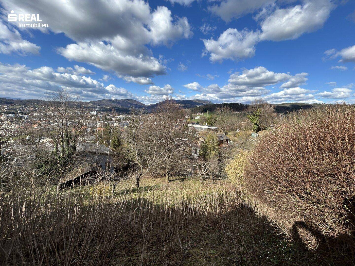 Weitläufiger Blick auf die Landschaft mit Bergen und bewölktem Himmel.