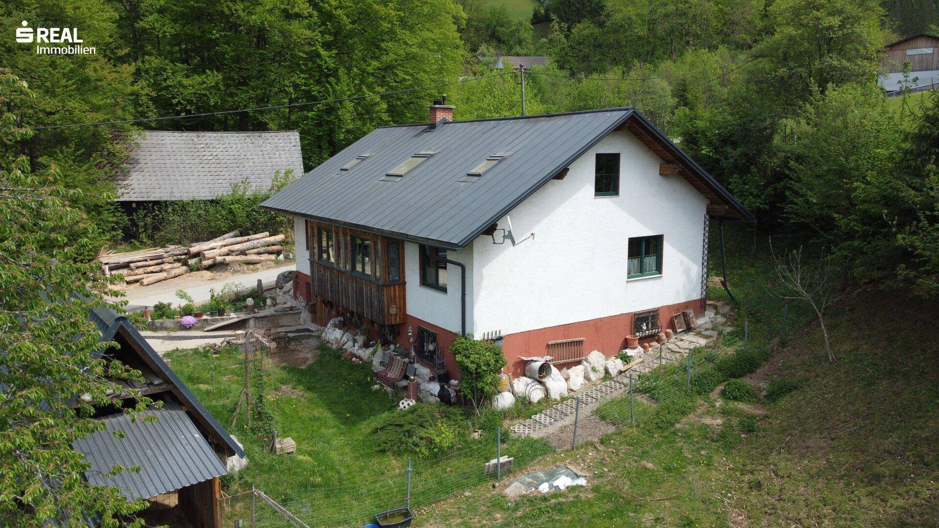 Rückansicht des Hauses mit Gartenbereich und Blick auf die umliegende Natur.