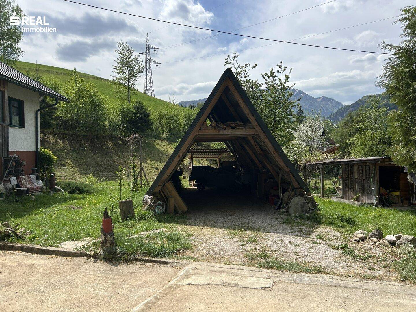 Offener Holzunterstand oder Carport mit Blick auf die umliegenden Berge.