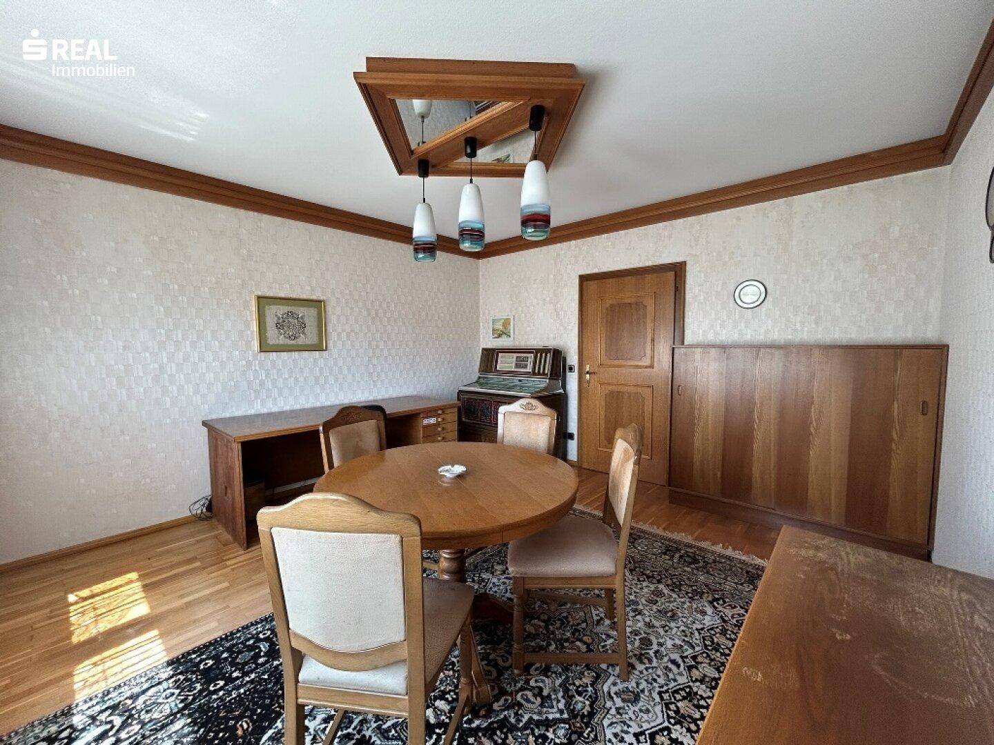 Klassisches Esszimmer mit Holztisch, Stühlen und Parkettboden, bietet Platz für gesellige Runden.