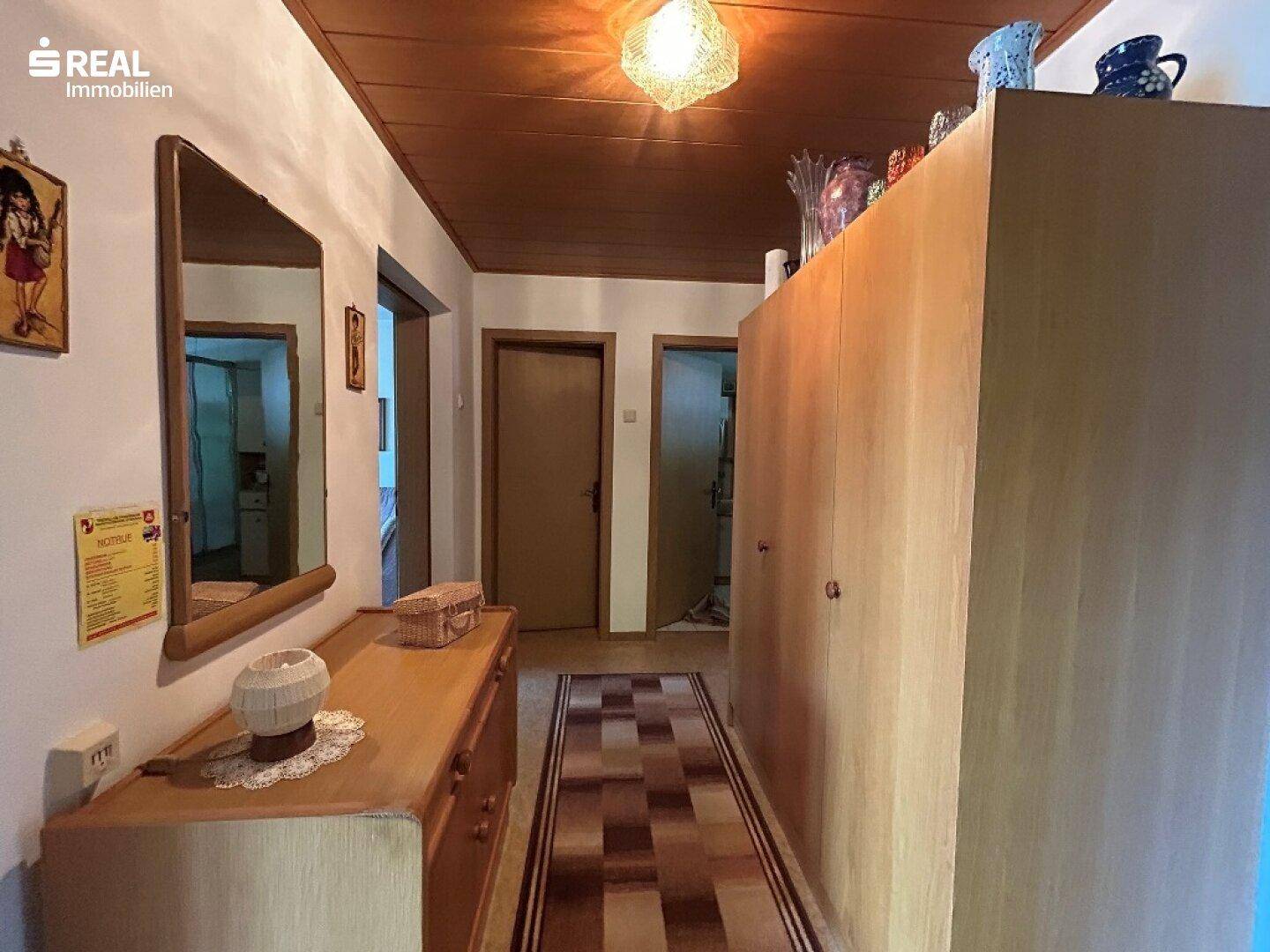 Heller Flur mit Holzdecke und Einbauschränken, bietet viel Stauraum und eine warme Atmosphäre.