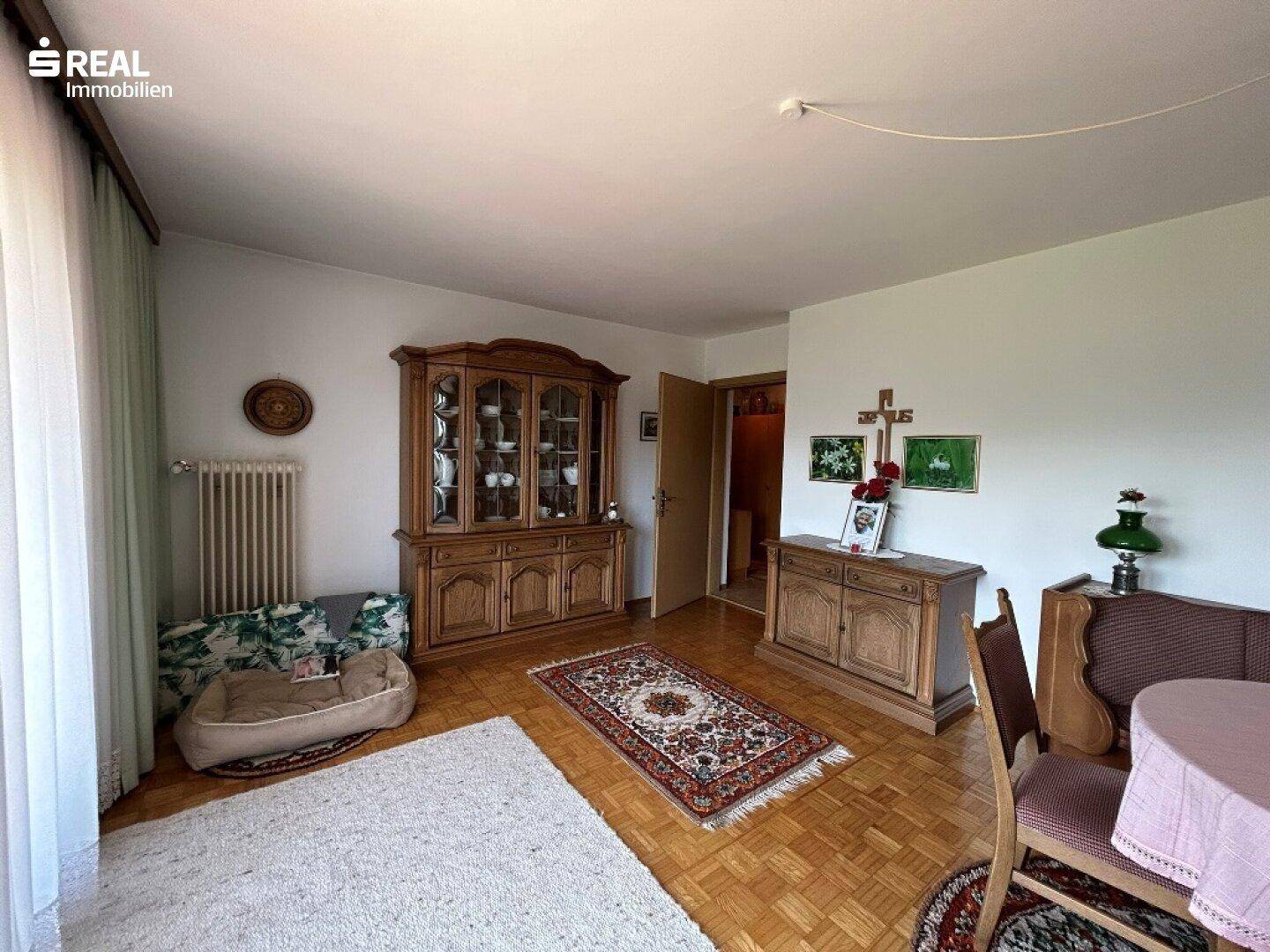 Wohnzimmer mit traditionellen Holzmöbeln, Parkettboden und einem gemütlichen Ambiente.