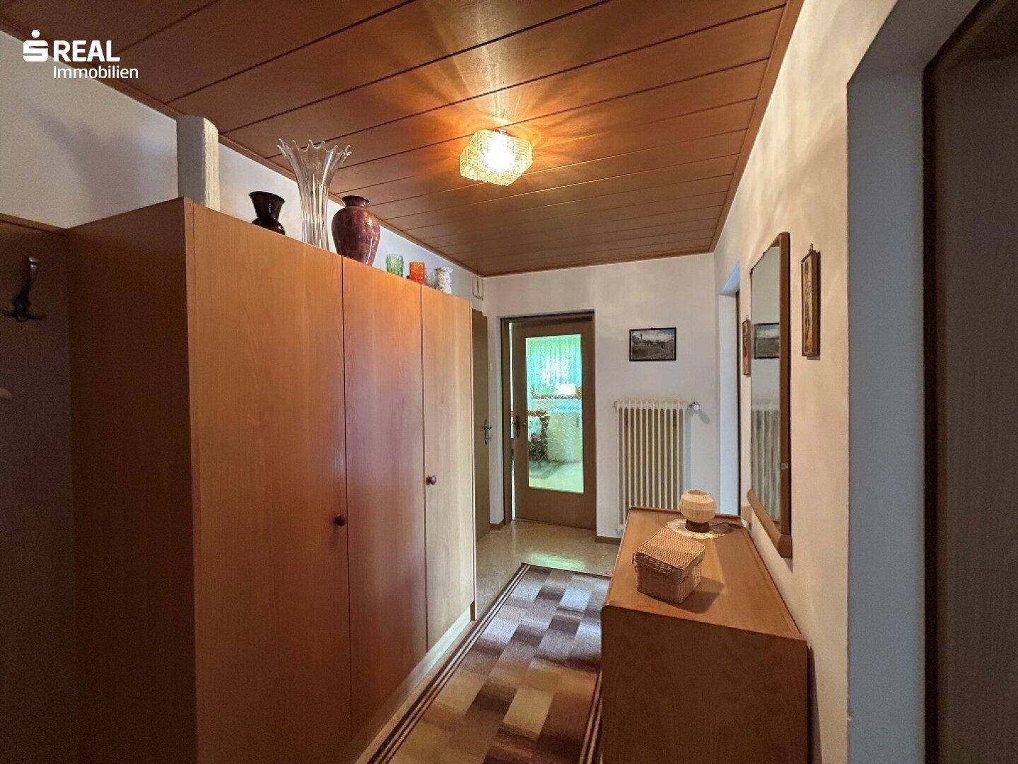Geräumiger Flur mit Holzdecke und Einbauschränken, bietet praktischen Stauraum.