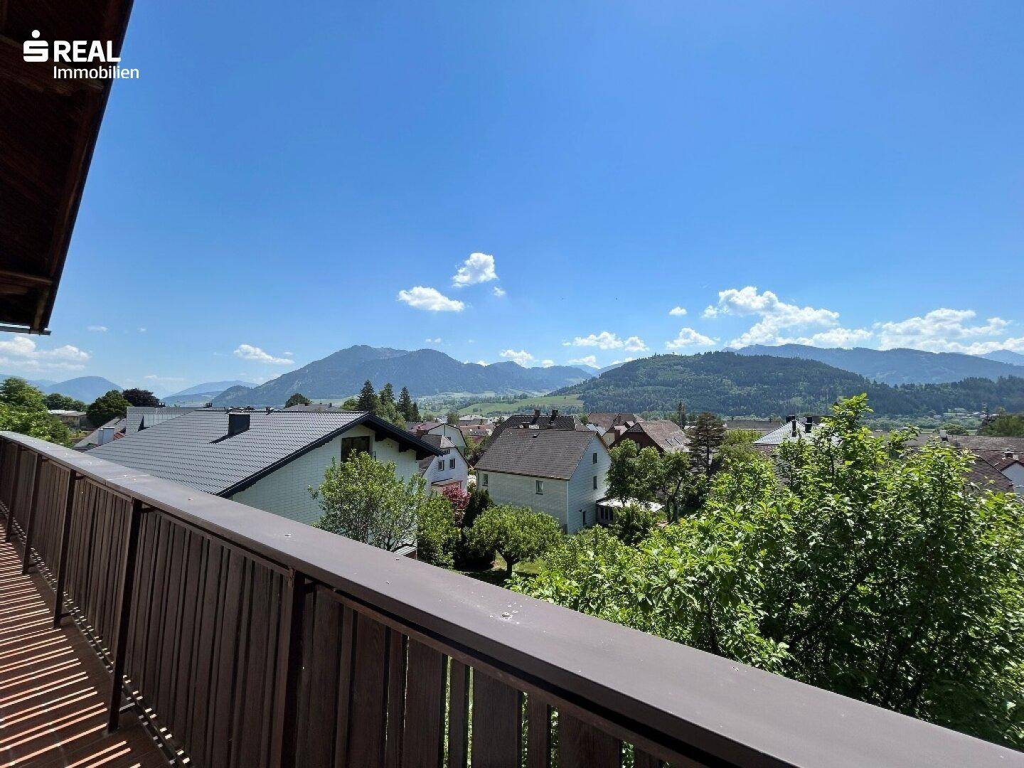 Balkon mit Panoramablick auf die umliegende Berglandschaft und grüne Täler.