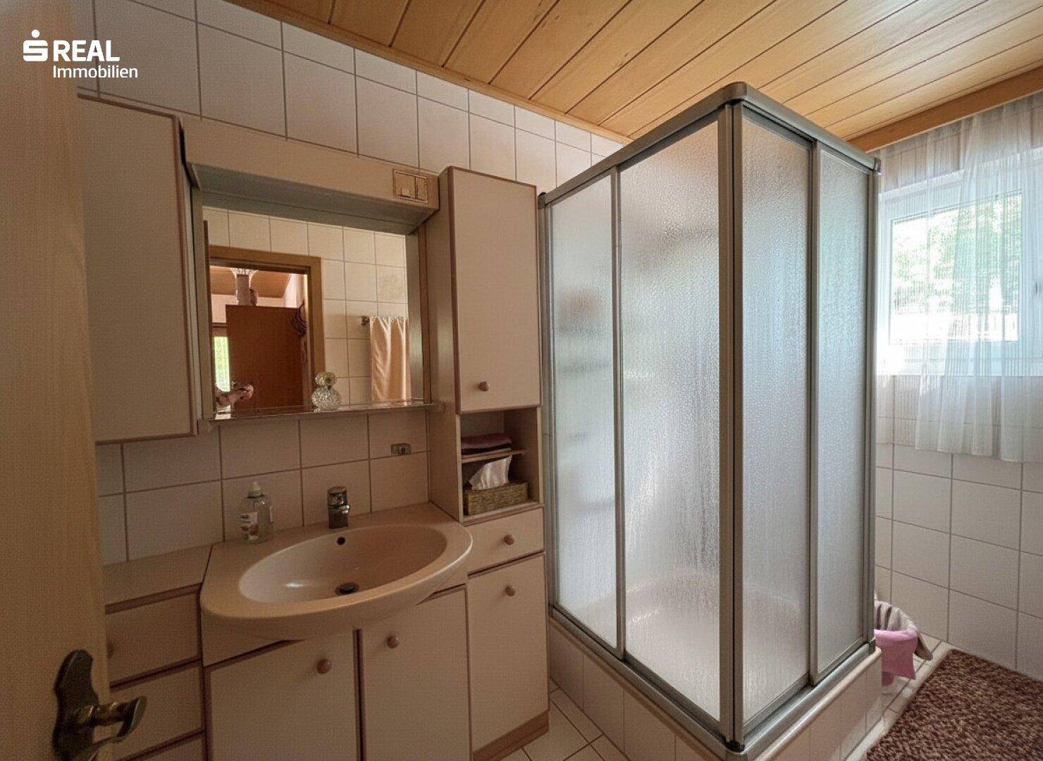 Badezimmer mit Duschkabine, Einzelwaschbecken und Fenster, in einem traditionellen Stil.