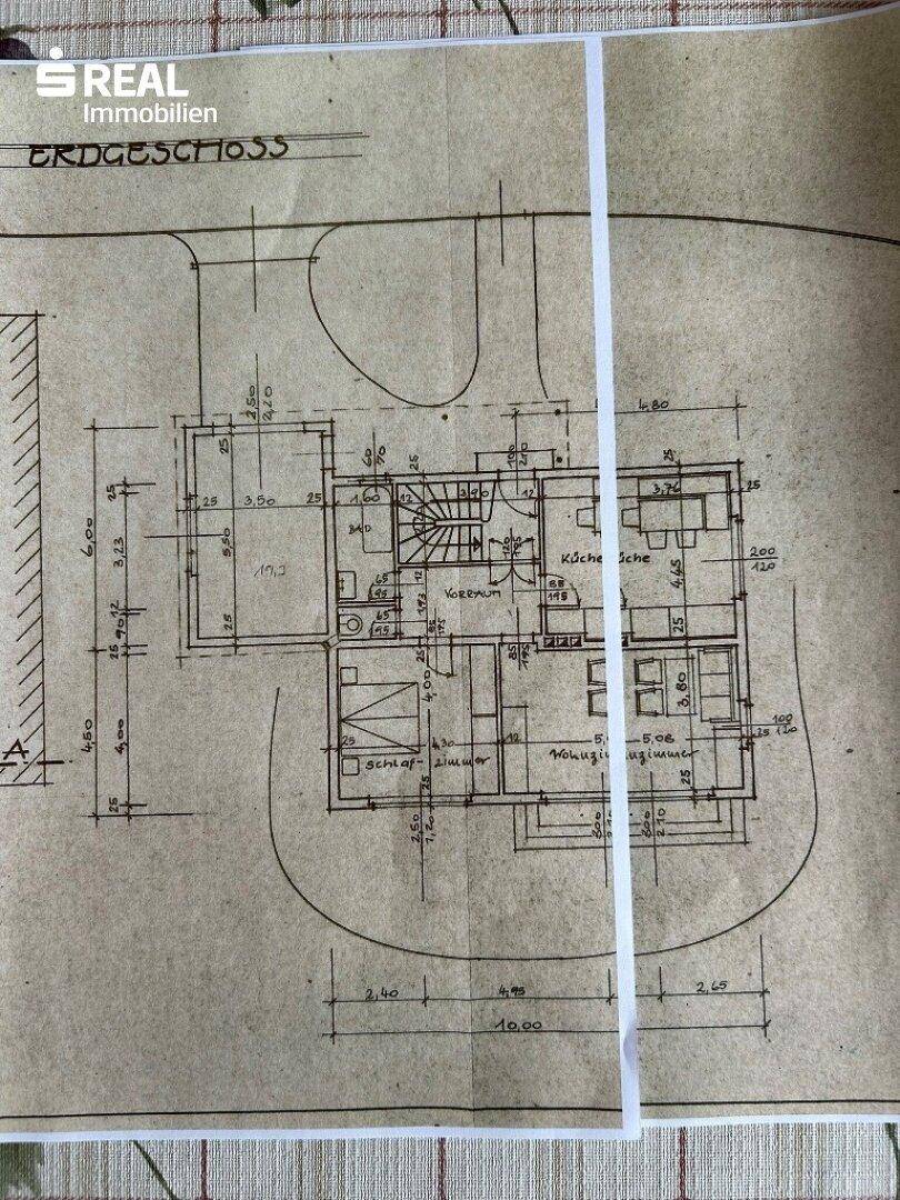 Grundriss des Erdgeschosses mit Schlafzimmer, Küche und Wohnzimmer.