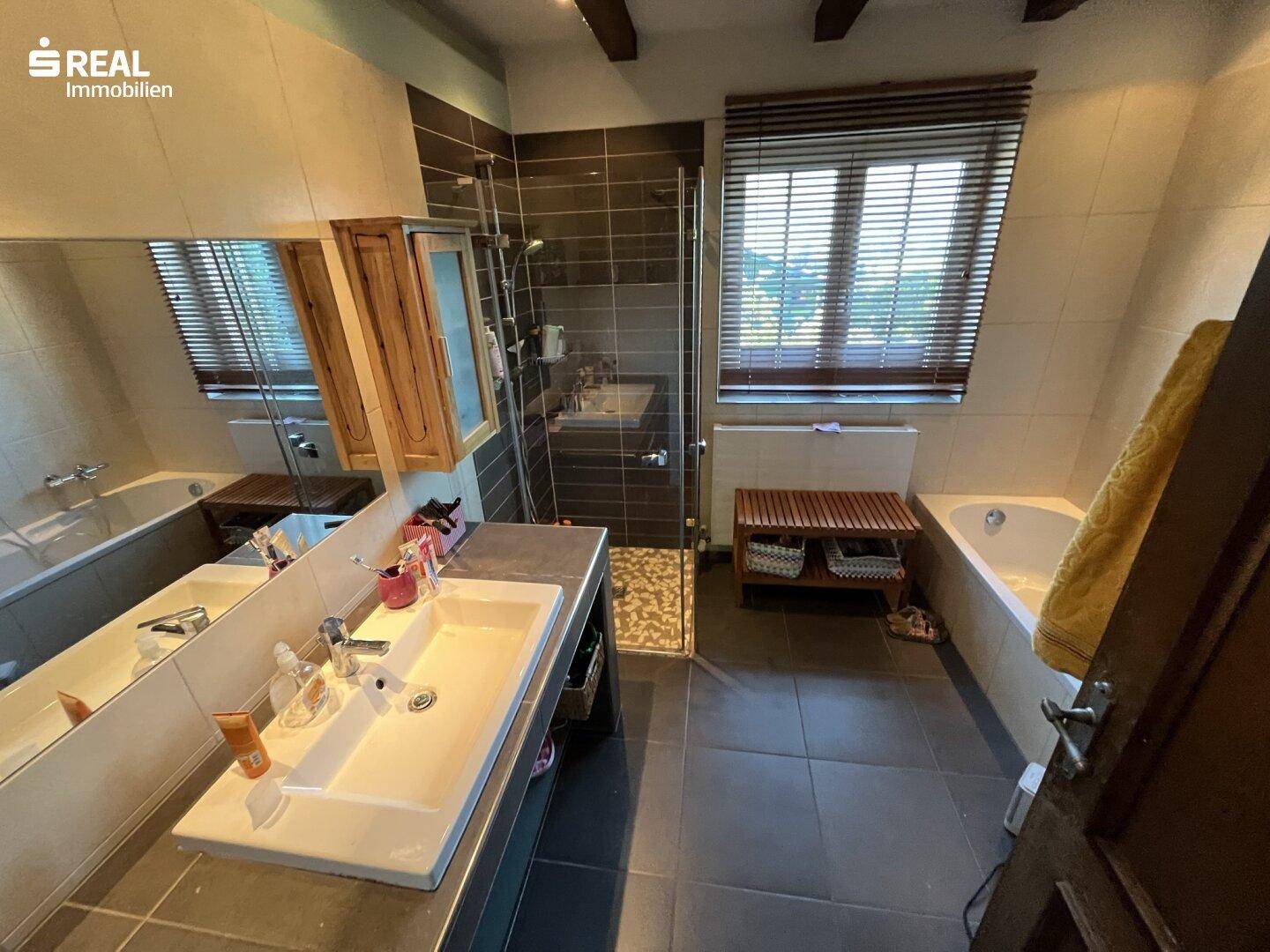 Modernisiertes Badezimmer mit Dusche, Badewanne und großem Waschbecken.